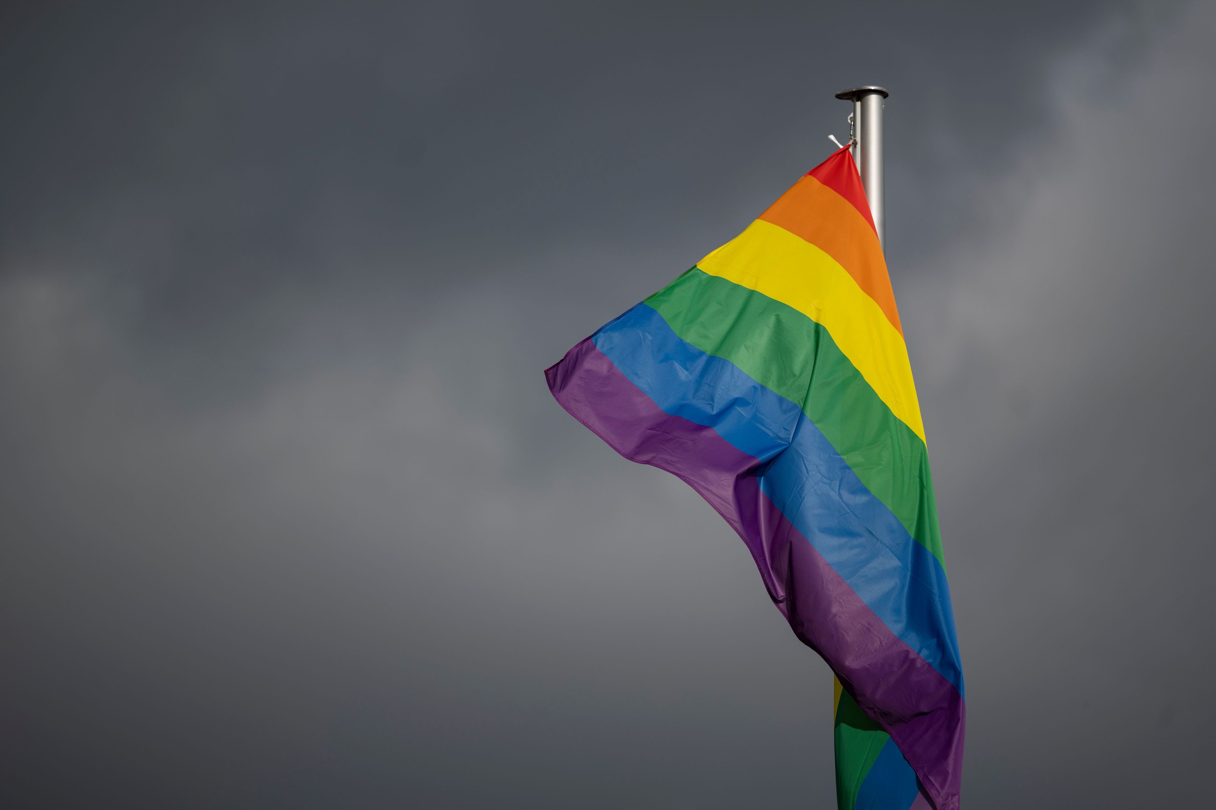 Eine Regenbogenflagge hängt an einem Mast. In Berlin war am Samstag am Rande des Christopher Street Day ein Mann mit einem Fahrzeug in eine Menschenmenge gefahren. (Archivbild)