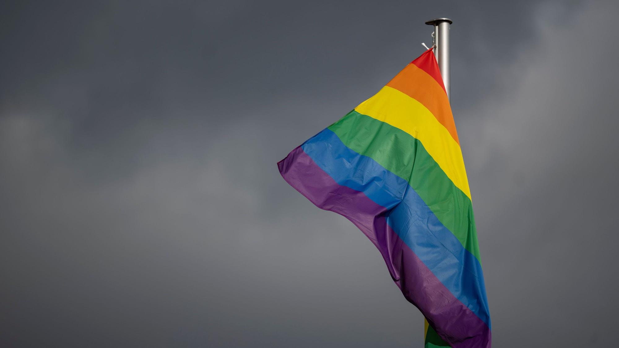 Eine Regenbogenflagge hängt an einem Mast. In Berlin war am Samstag am Rande des Christopher Street Day ein Mann mit einem Fahrzeug in eine Menschenmenge gefahren. (Archivbild)