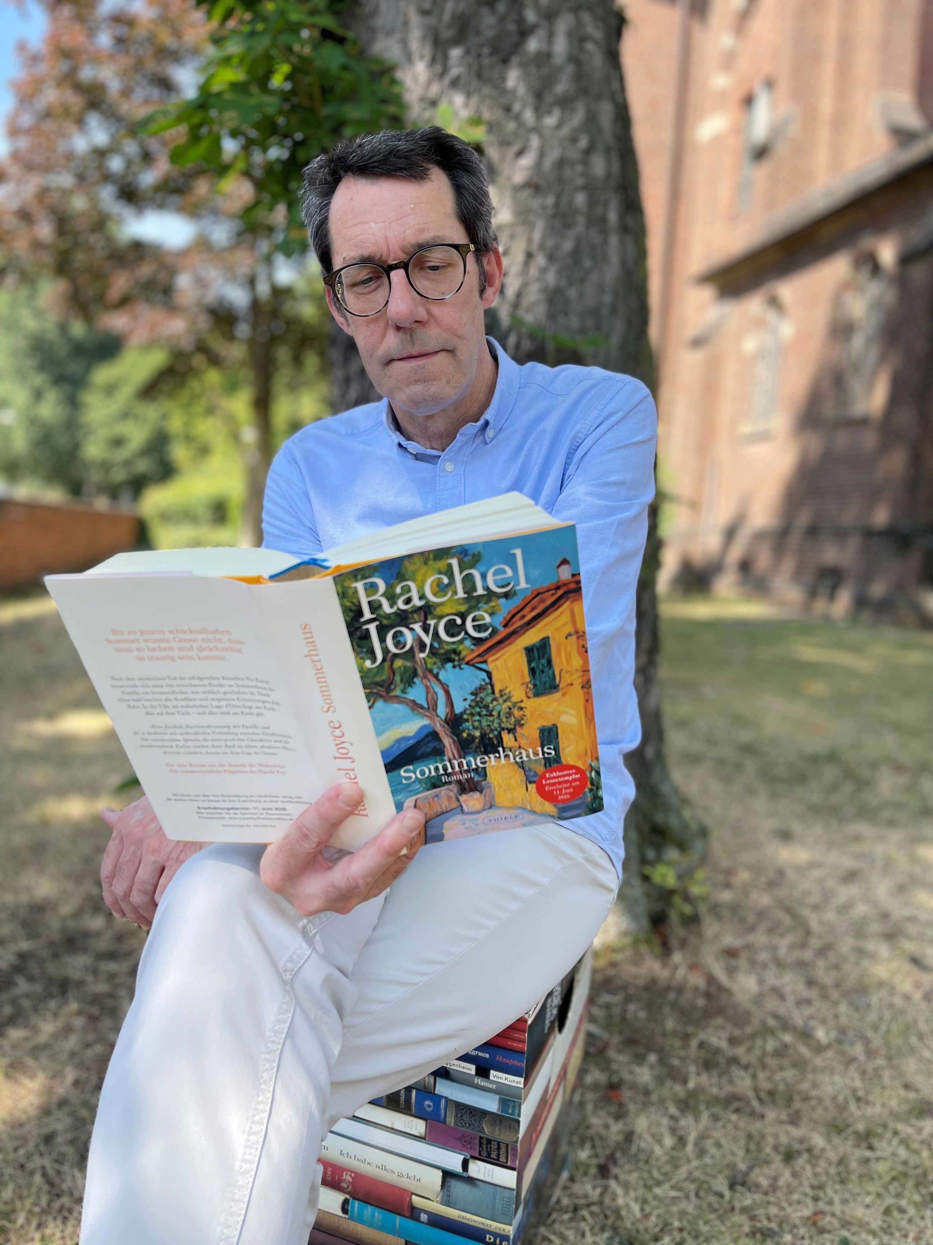 Jens Bartsch mit Buch unter einem Baum