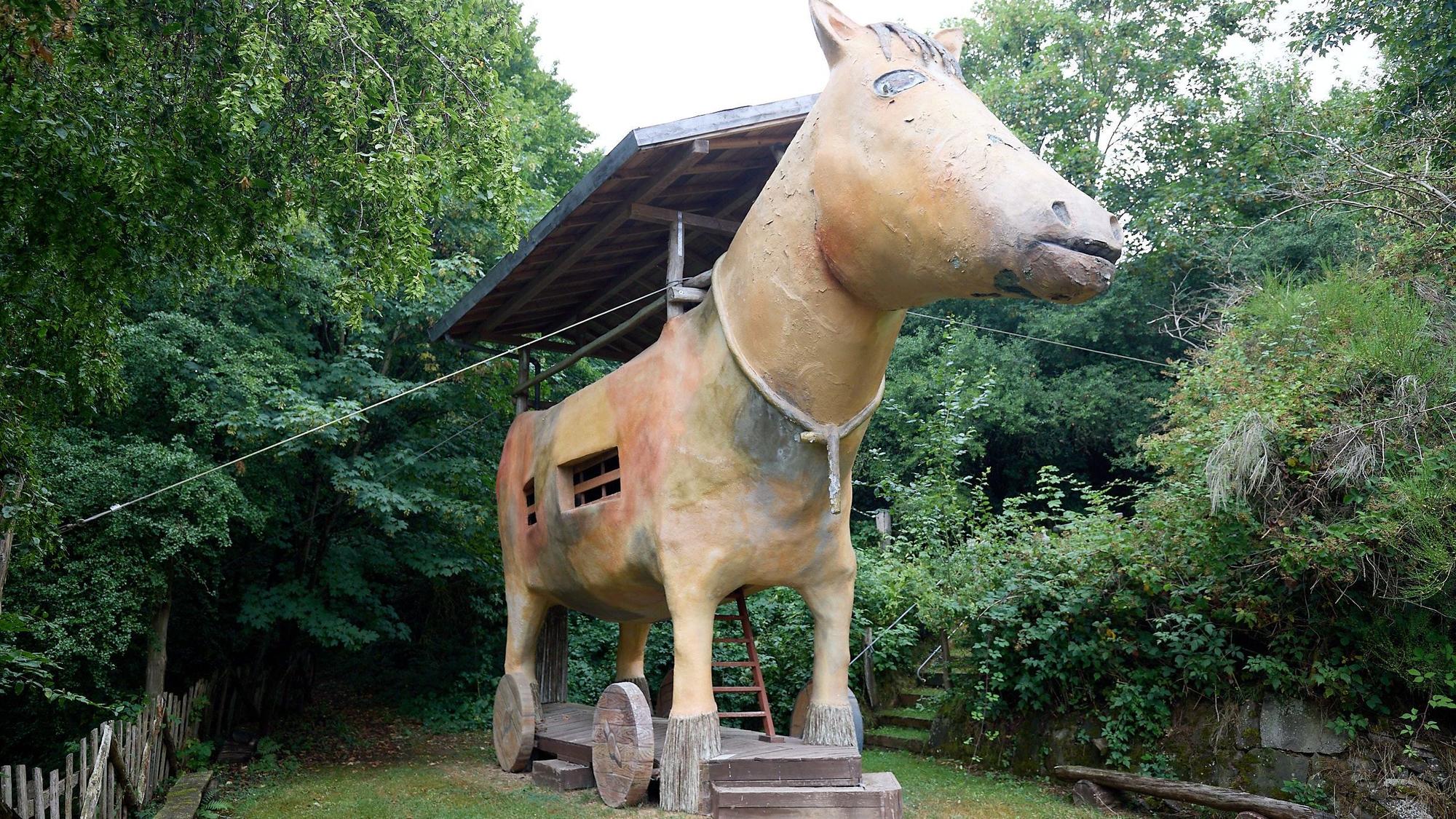 Das große hölzerne Pferd auf Rädern steht in einer Ecke des weitläufigen Geländes.