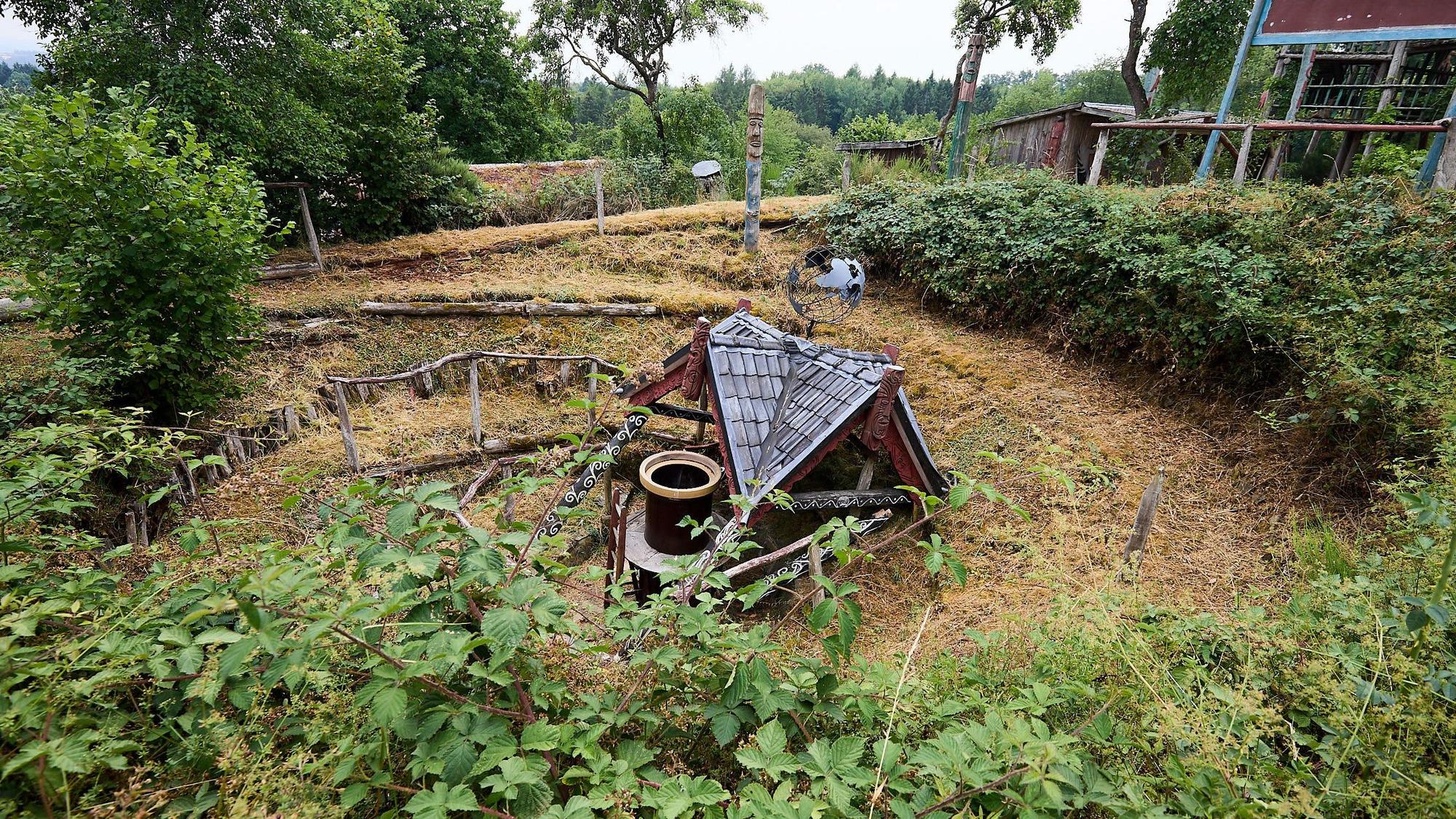 Das zusammengefallen Maorihaus. Darum windet sichdie Erdspirale.