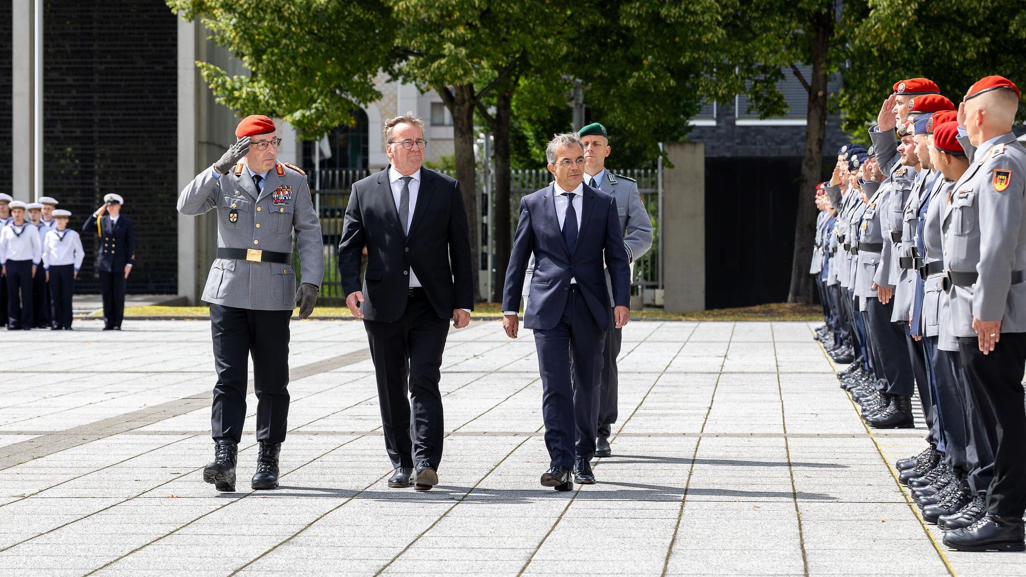 Der Kölner Schriftsteller Navid Kermani (rechts) schreitet beim Feierlichen Gelöbnis von Rekrutinnen und Rekruten der Bundeswehr am 20. Juli 2026 im Bendlerblock Berlin eine Reihe angetretener Soldaten ab. Neben ihm Generalinspekteur Carsten Breuer (links) und Verteidigungsminister Boris Pistorius (Mitte)