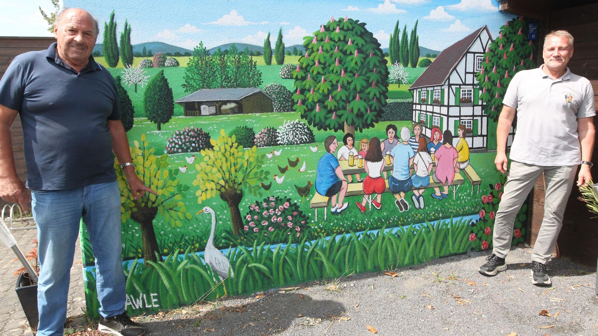 Der Spicher Maler Josef Hawle (links) hat die Mauer im Biergarten des Eschmarer Brauhauses mit dem für ihn typischen naiven Realismus bemalt. Auftraggaber war Olaf Piprek (rechts).