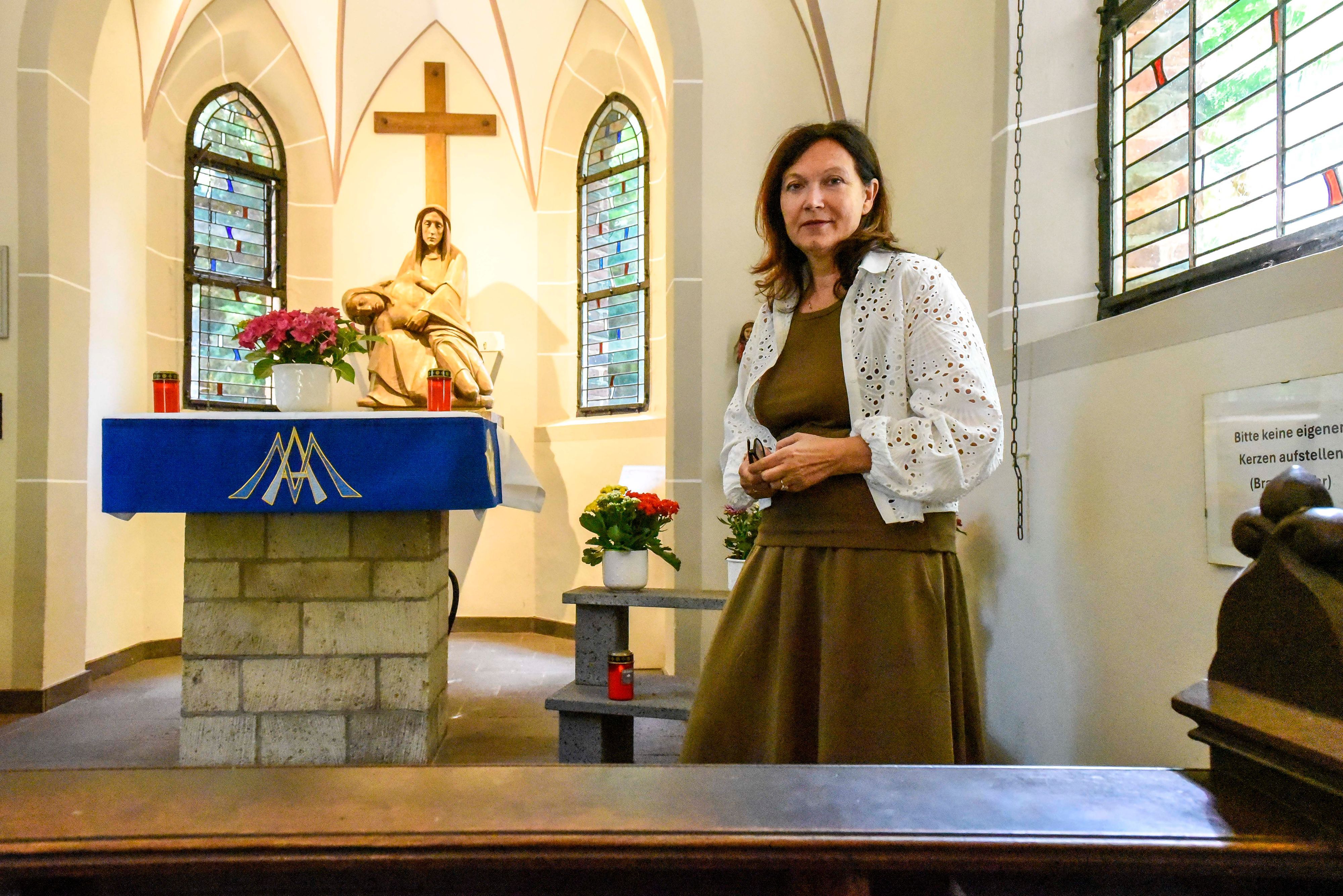 Eine Frau steht in einer Kapelle.