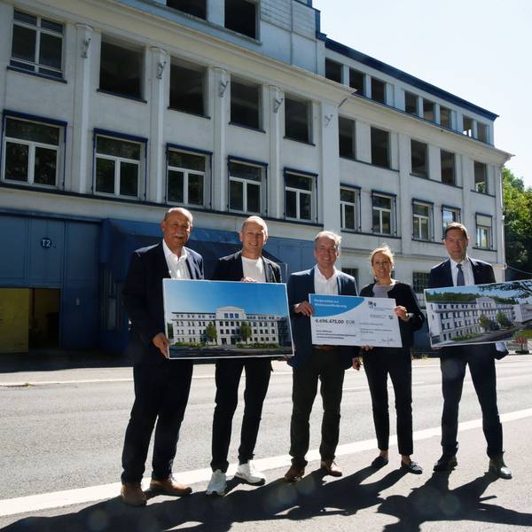 Fünf Personen vor einem alten Gebäude.