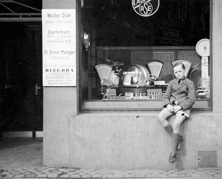 Der kleine Wolfgang nach dem Krieg vor dem Waagen-Geschäft seiner Eltern am Kölner Apellhofplatz.