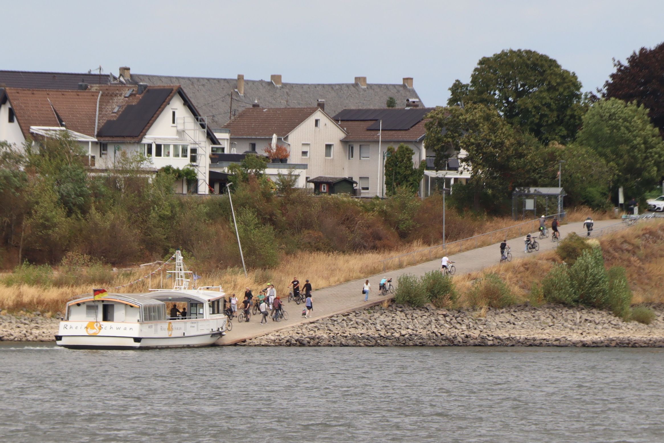 Das Bild zeigt, wie Personen die Fähre Rheinschwan verlassen und betreten.