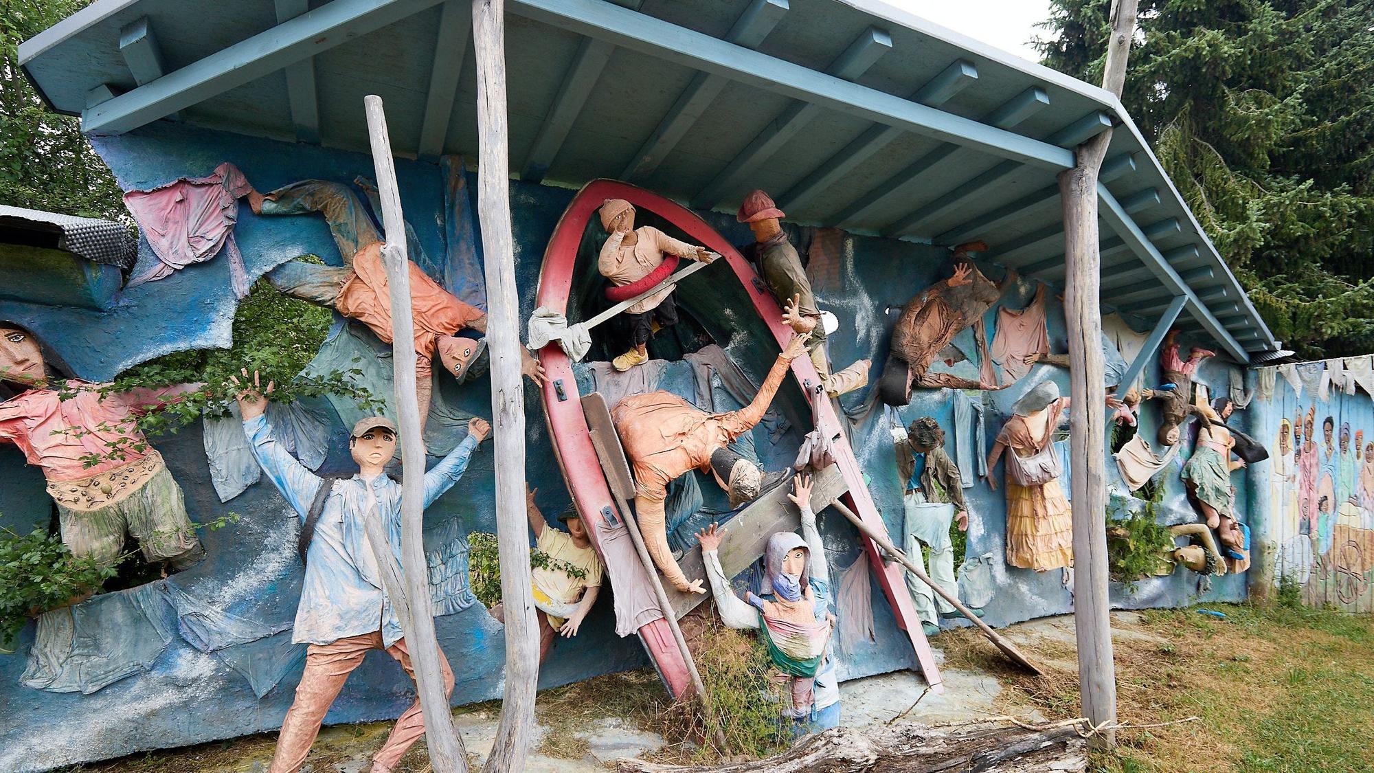 Zahlreiche Figuren dokumentieren an einem Relief das Sterben im Mittelmeer.
