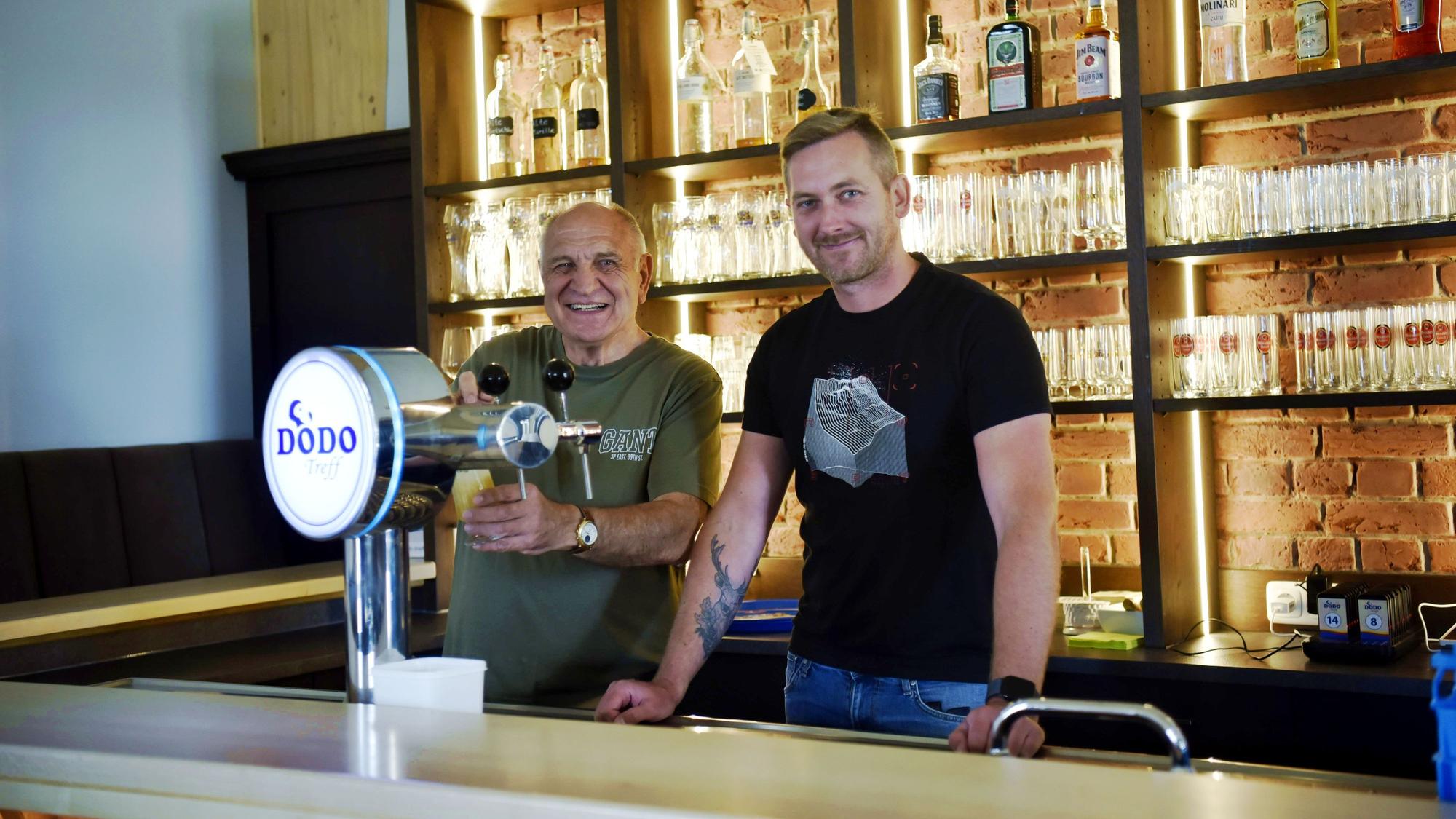 Hans-Josef Wolf und Tim Ziegler stehen an der Zapfanlage hinter der Theke des Dodo-Treffs.