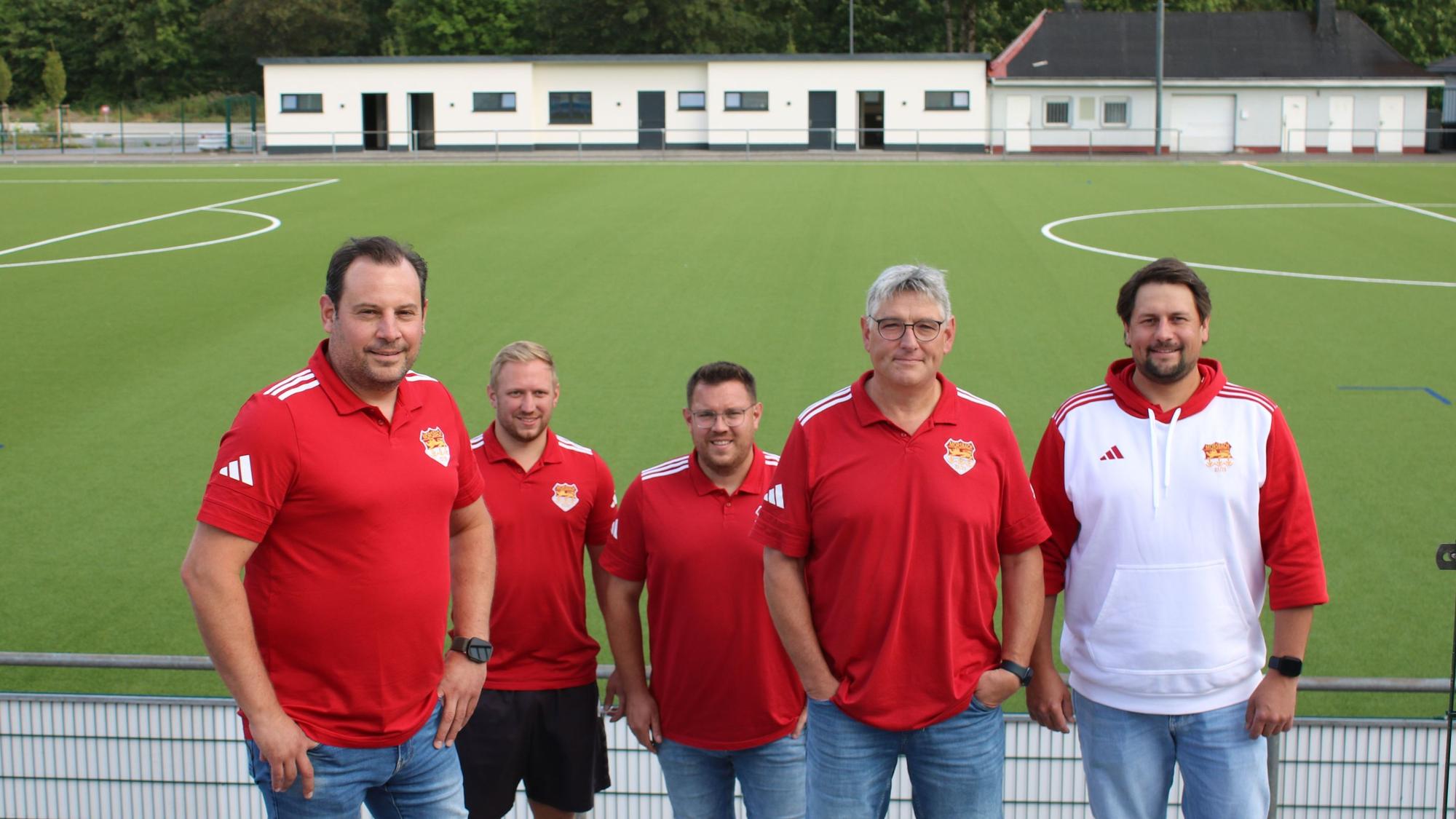Gruppenfoto vor dem frisch sanierten Sportplatz.