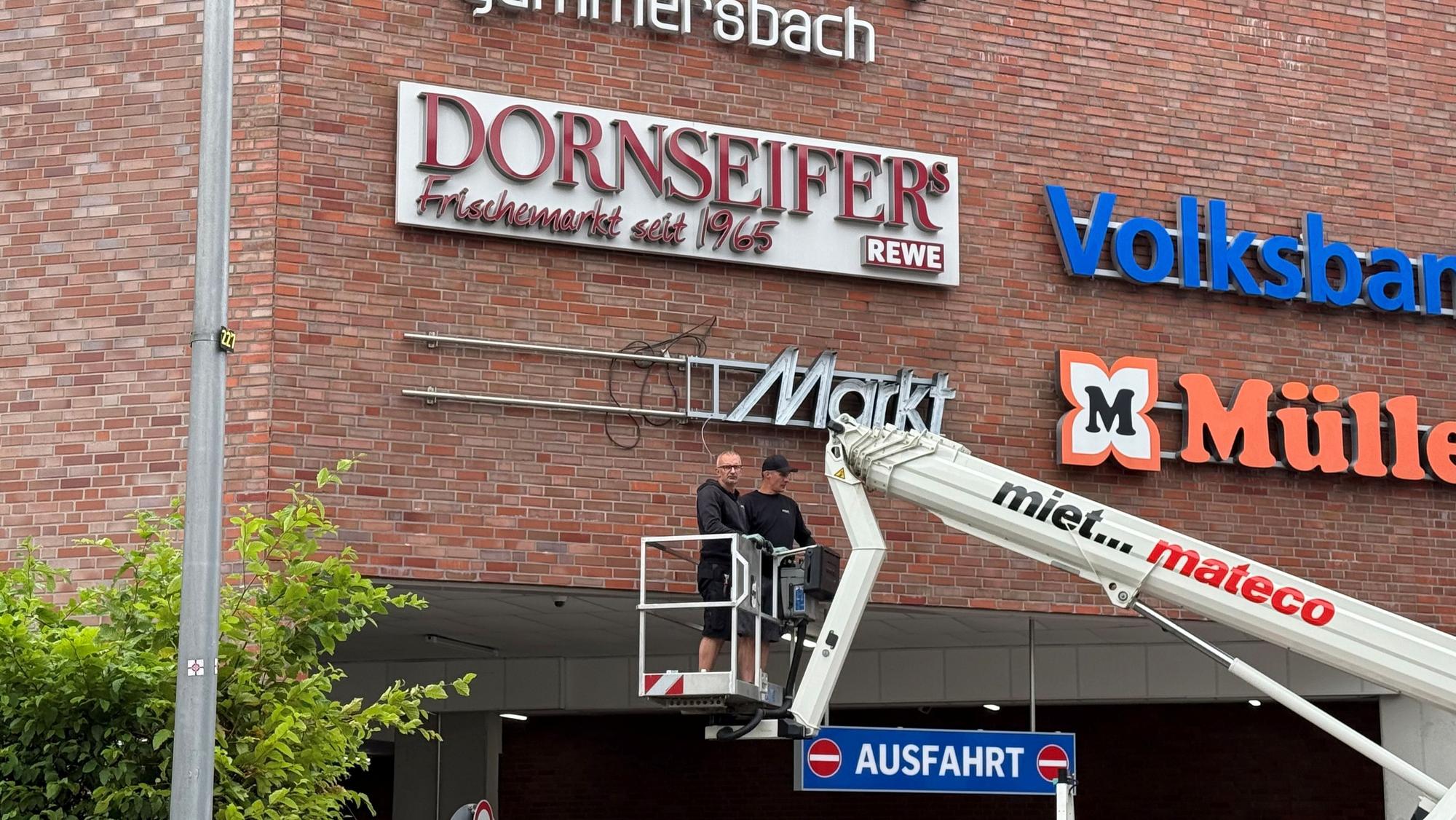 An der Außenfassage eines Einkaufszentrums wird das Logo von „MediaMarkt“ installiert.