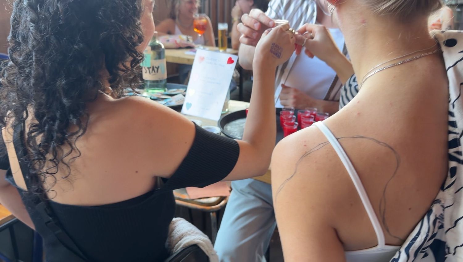 Drei Besucher stoßen mit einem Shot an.