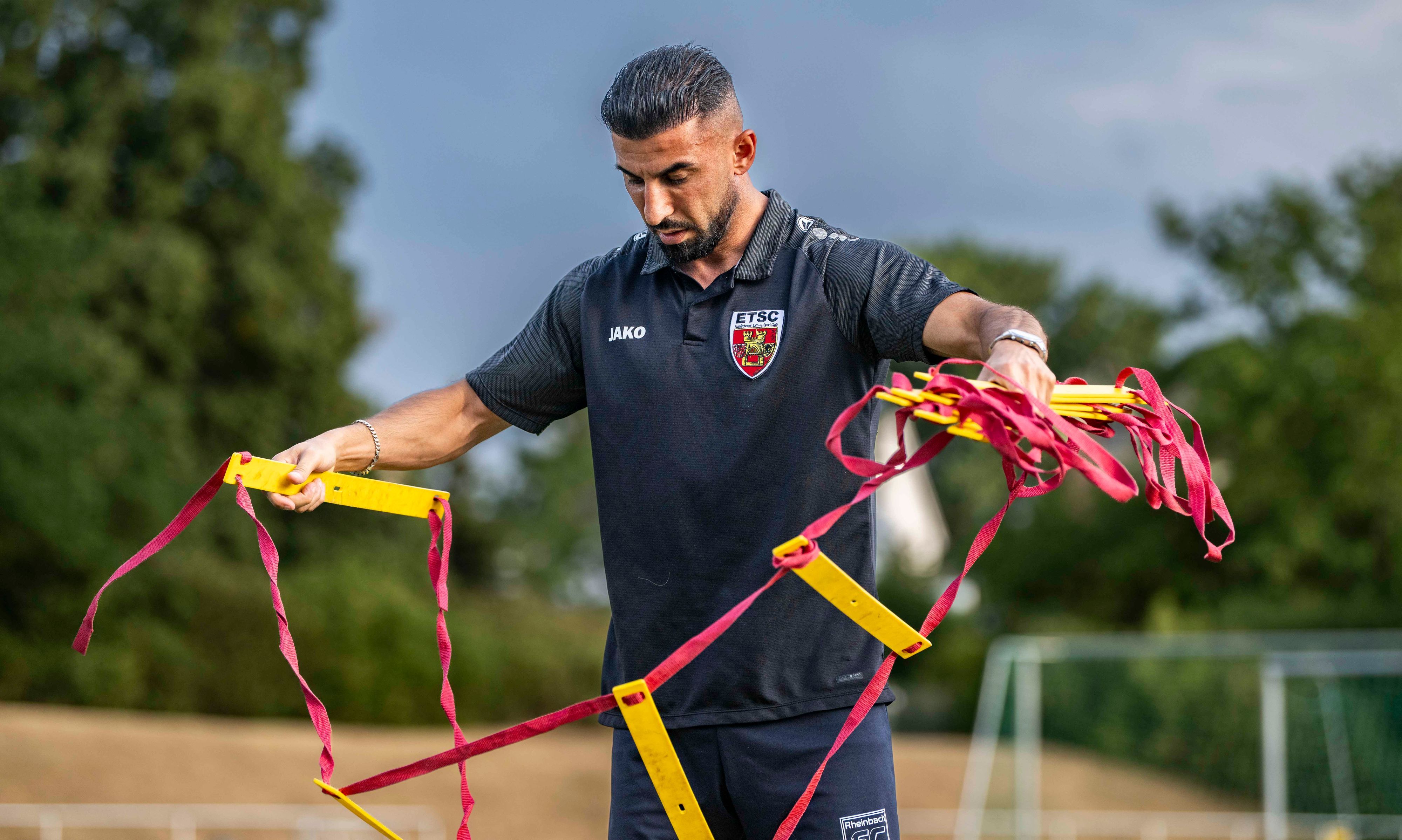Das Bild zeigt Ulas Önal, der eine Trainingsleiter aufbaut.
