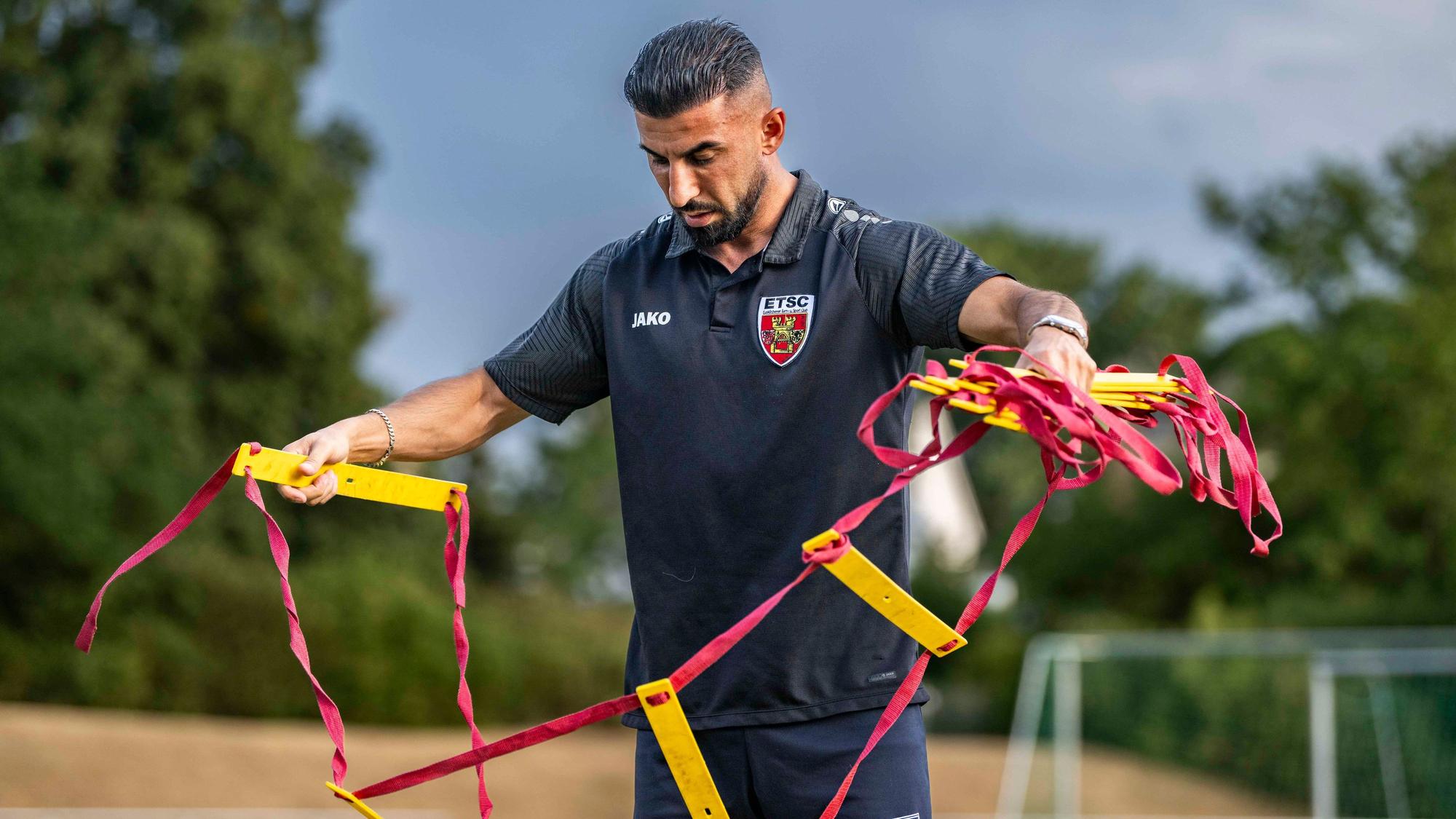 Das Bild zeigt Ulas Önal, der eine Trainingsleiter aufbaut.
