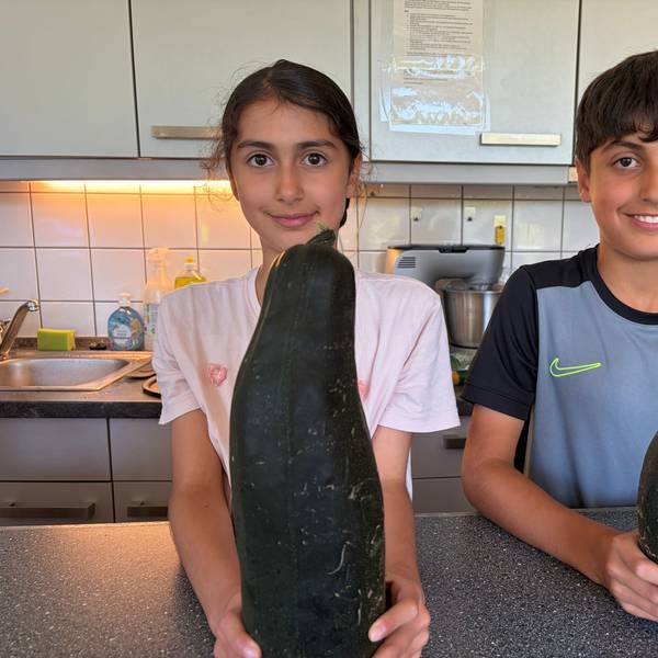 Stolz auf die eigene Ernte: Solin und Ahmed mit Zucchini aus dem Jugendhaus-Garten