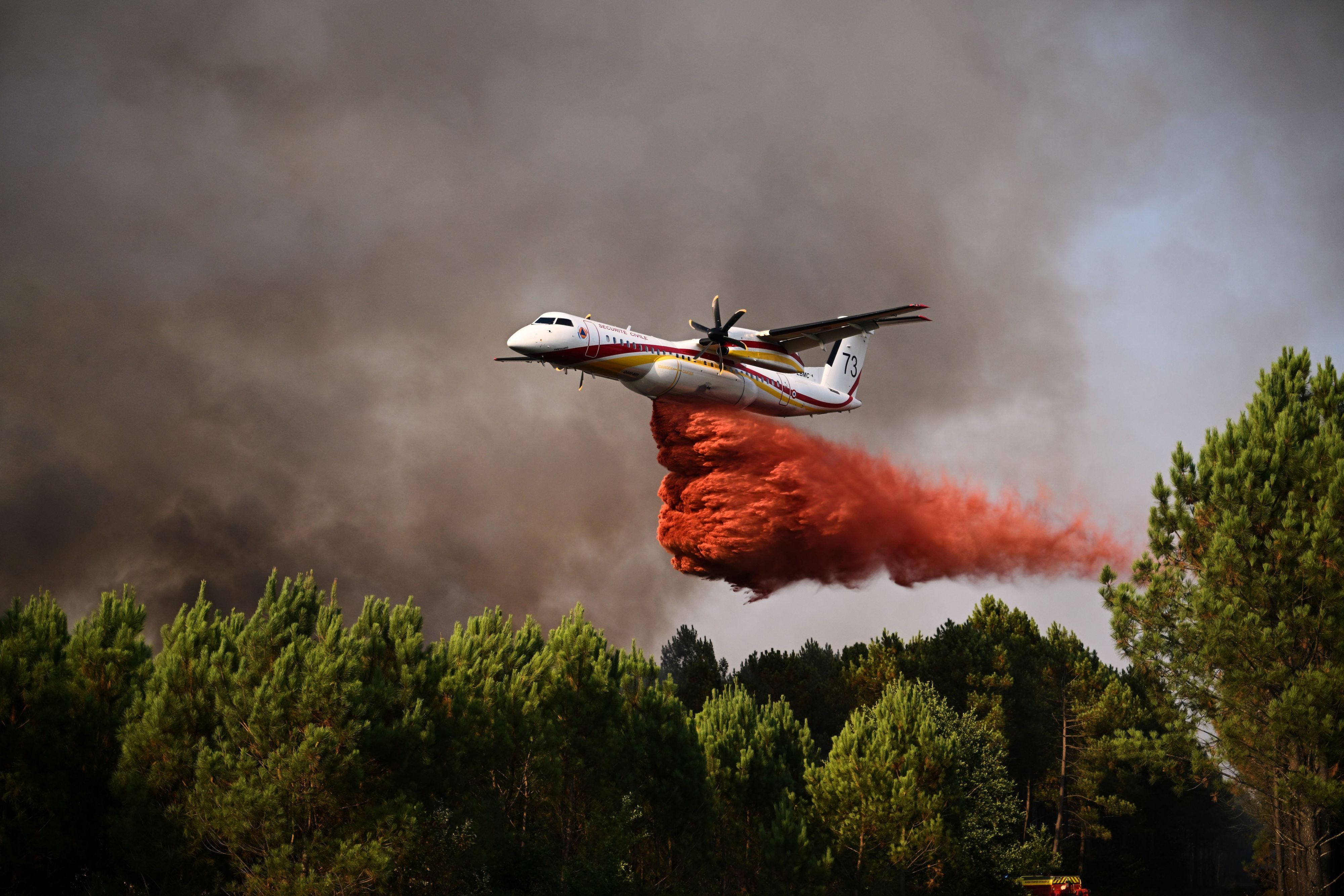 29.07.2026, Frankreich, Blagon: Eine De Havilland Canada Dash 8-400 versprüht Löschmittel, während sie bei den Waldbränden im Südwesten Frankreichs über einen Wald fliegt. Foto: Emma Da Silva/AP/dpa +++ dpa-Bildfunk +++