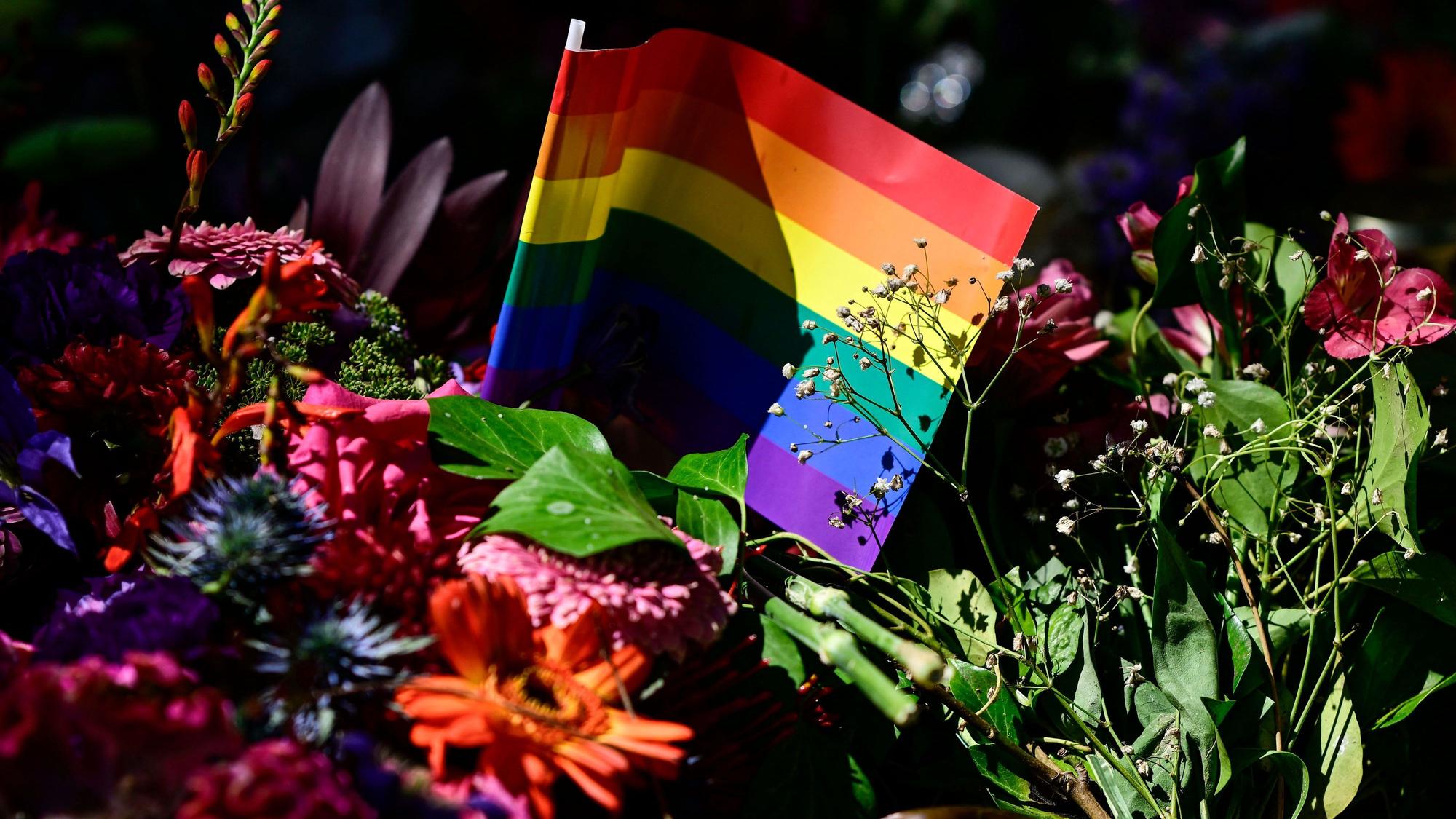 Flowers, a candle and a rainbow flag have been placed at a makeshift memorial in tribute to the victims at the Tiergarten park in Berlin on July 28, 2026, three days after a car ramming attack that killed one person and injured 29 near the Christopher Street Day (CSD) parade. German police had shot and killed the chief suspect in what officials described as a deadly Islamist attack near the Berlin Pride parade the night prior, the latest ramming assault to hit the country. The attack late on July 25 -- the first such incident to target the German capital's LGBTQ community, killed one woman and wounded 29 others. (Photo by John MACDOUGALL / AFP)