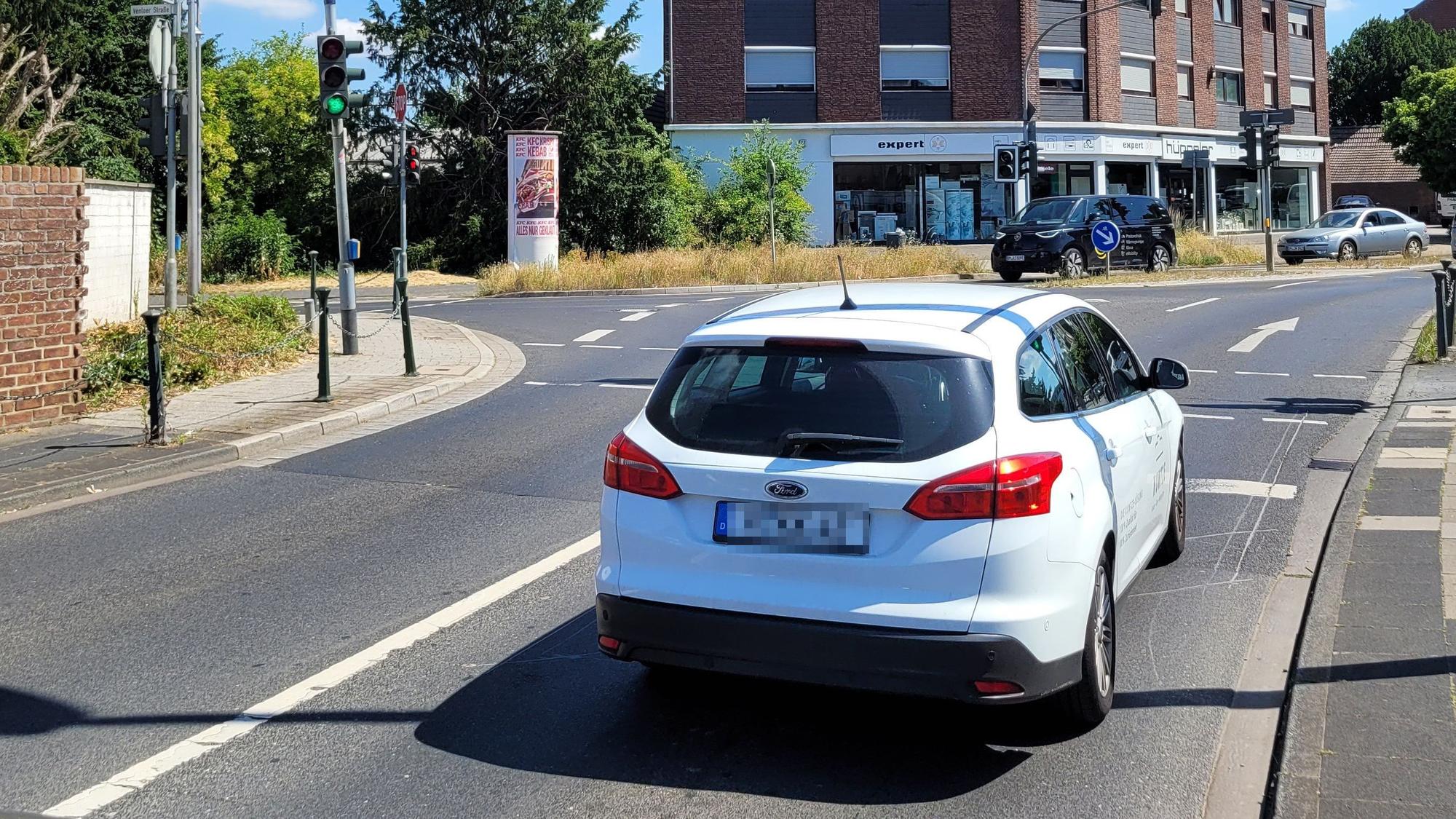Ein Auto fährt auf eine Ampel zu.