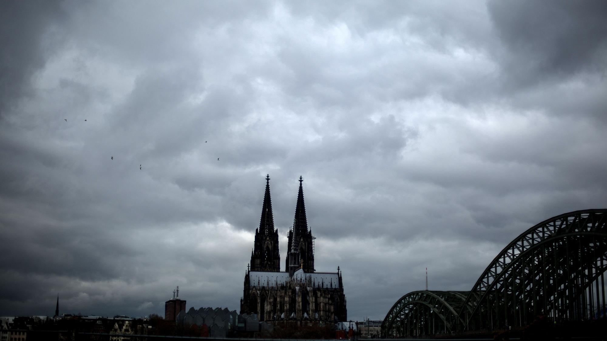 Dunkle Wolken ziehen in Köln am Dom vorbei. (Archivbild)