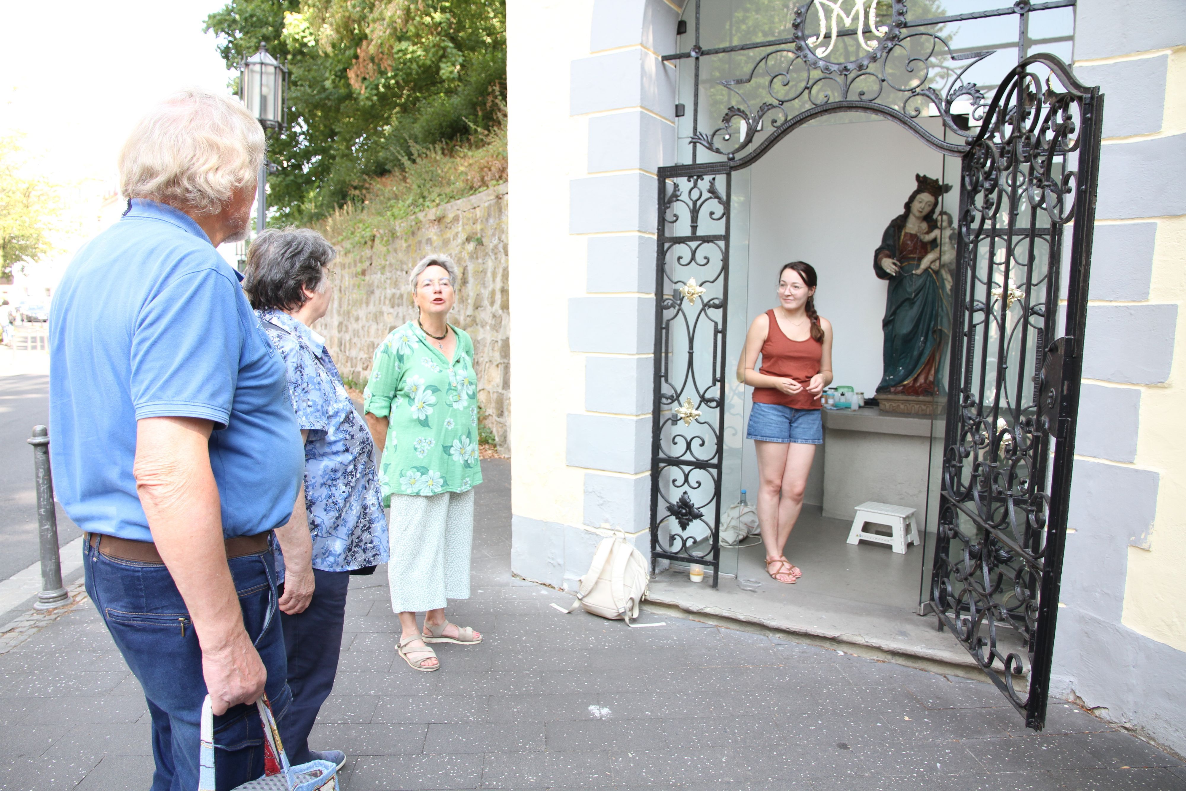 Johanna Baldus (rechts) restauriert die Marienfigur in der kleinen Kapelle an der Siegburger Mühlenstraße, mit Andrea Korte-Böger (2. von rechts)