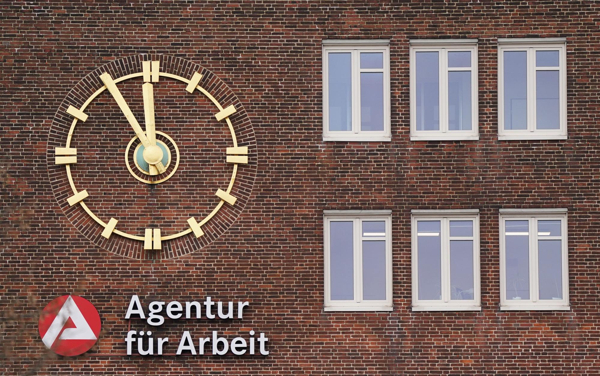 Die Uhr an der Fassade der Agentur für Arbeit zeigt fünf Minuten vor Zwölf an.