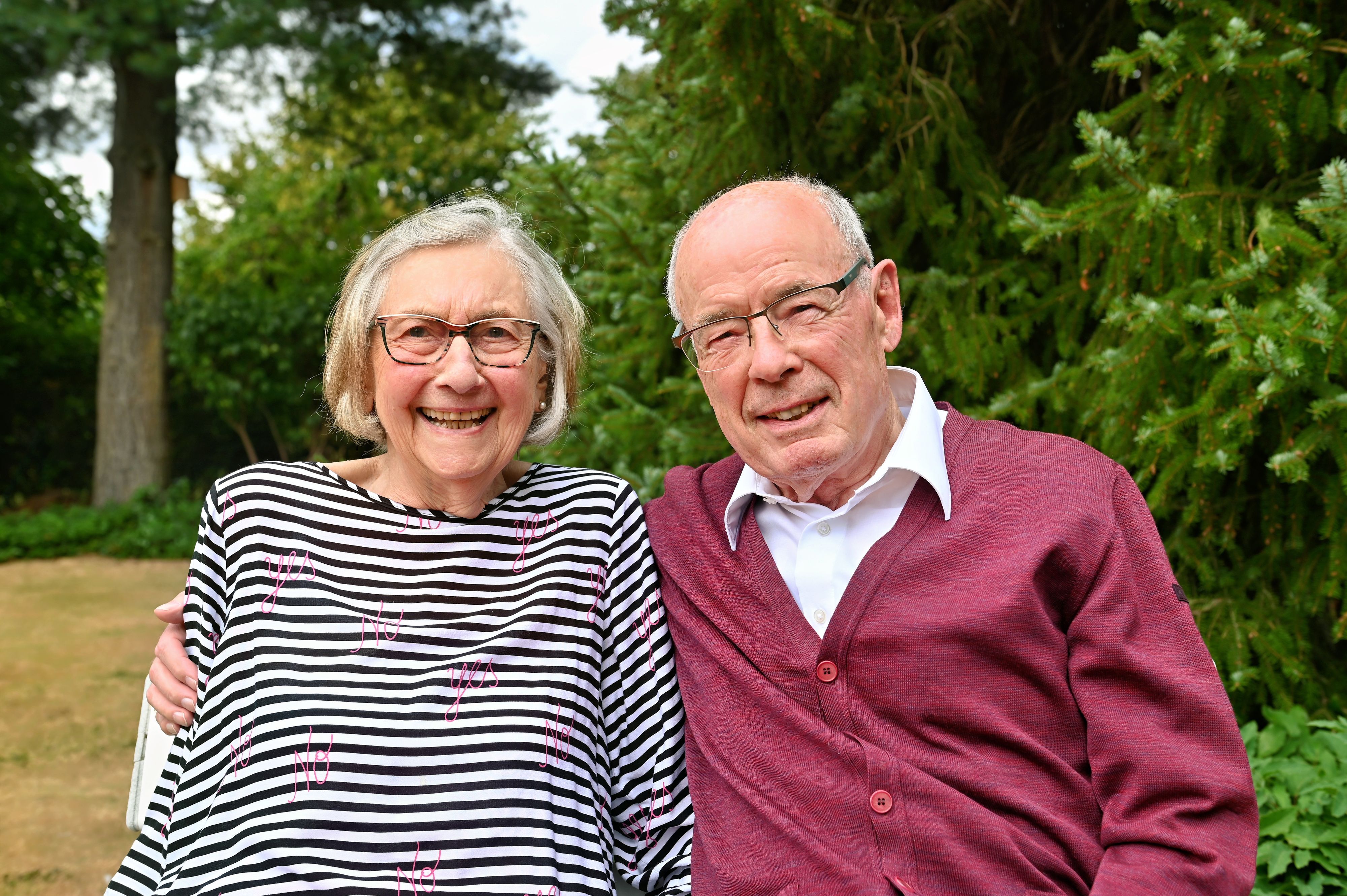 Helga und Ernst Jonas sitzen nebeneinander im Grünen, er hat den Arm um sie gelegt.