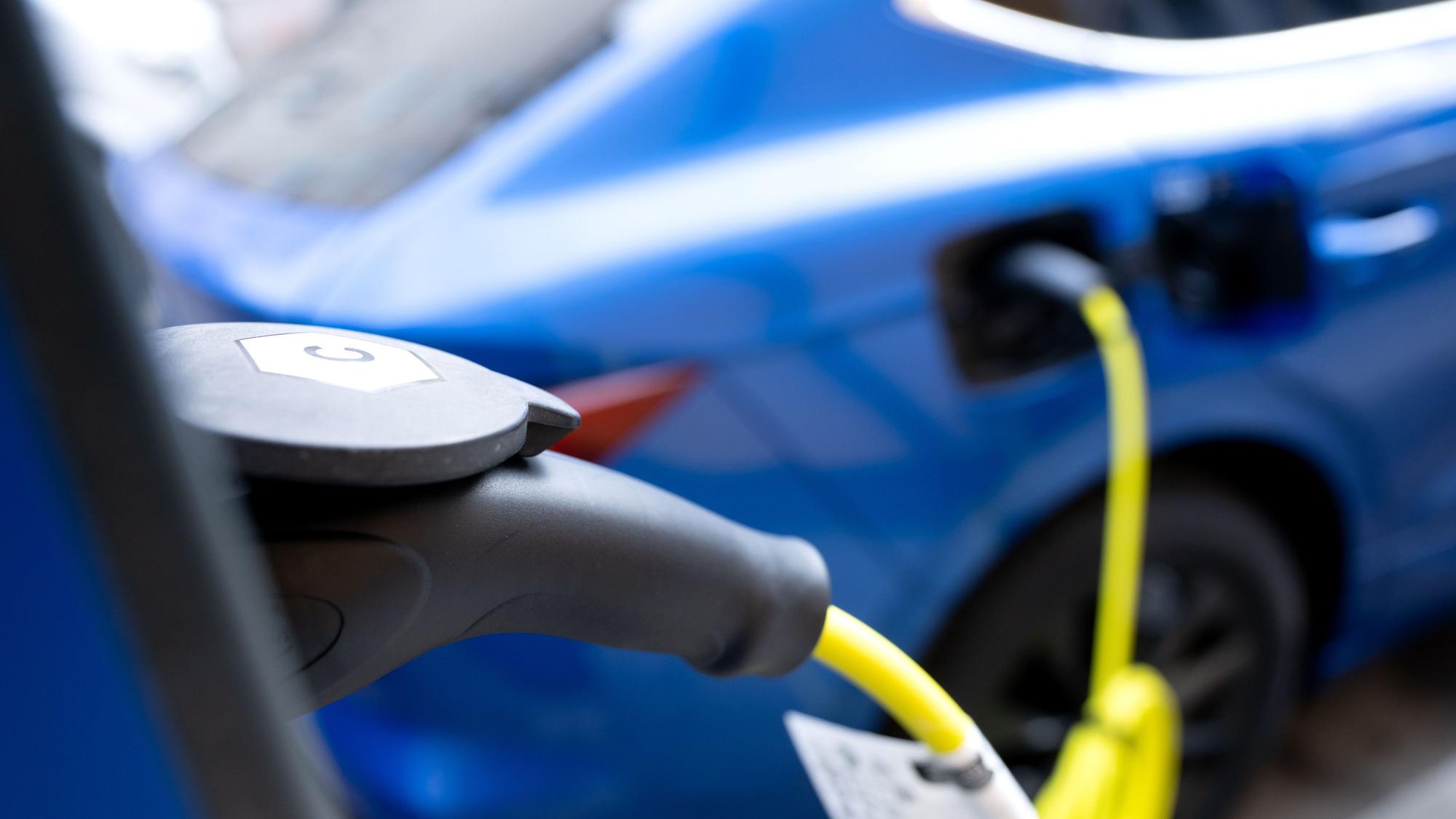 Ein Elektroauto steht in der Innenstadt an einer Ladesäule