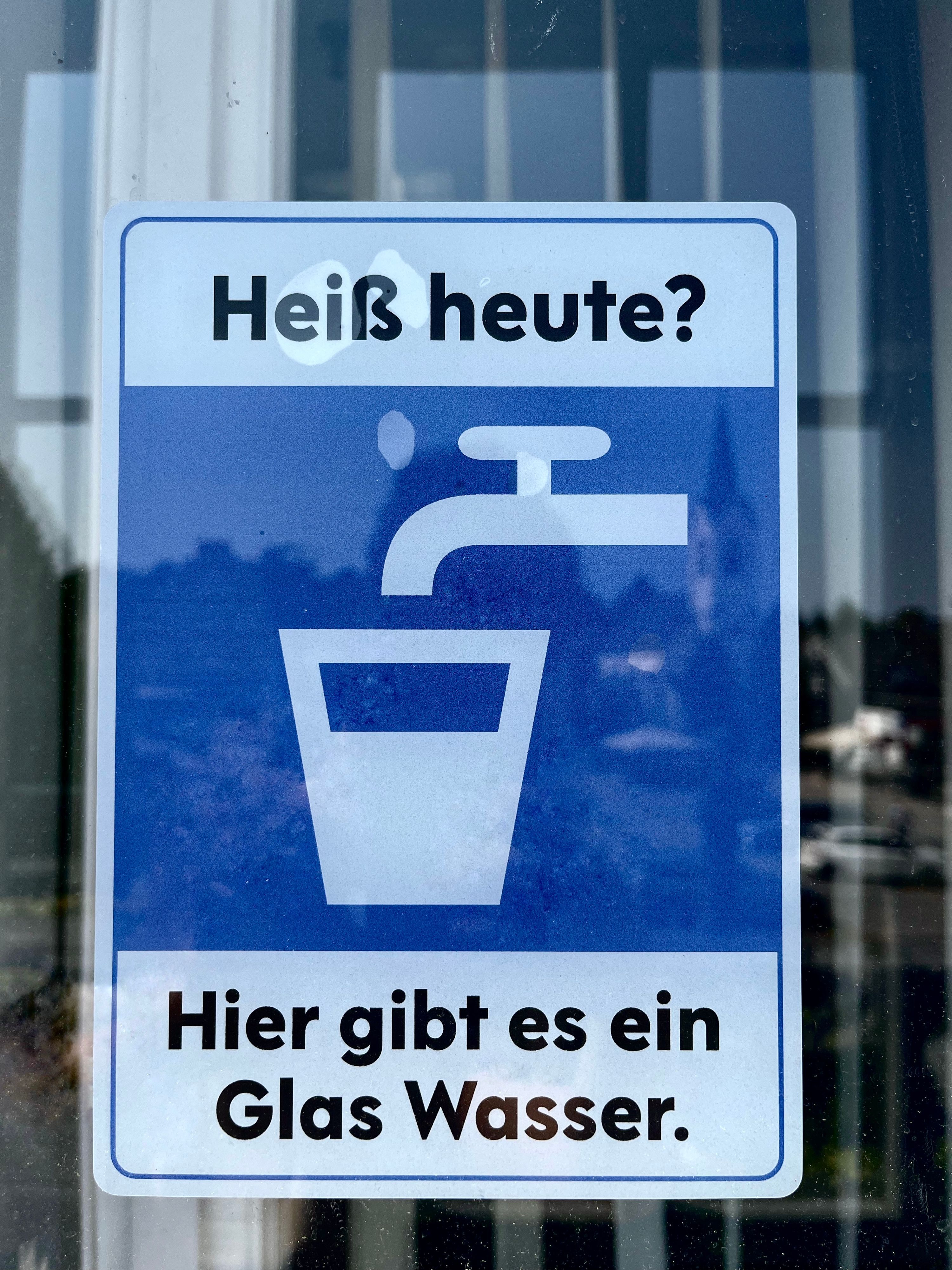 Ein Aufkleber, auf dem steht: „Hier gibt es ein Glas Wasser.“