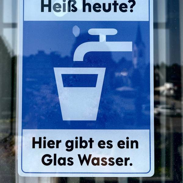 Ein Aufkleber, auf dem steht: „Hier gibt es ein Glas Wasser.“