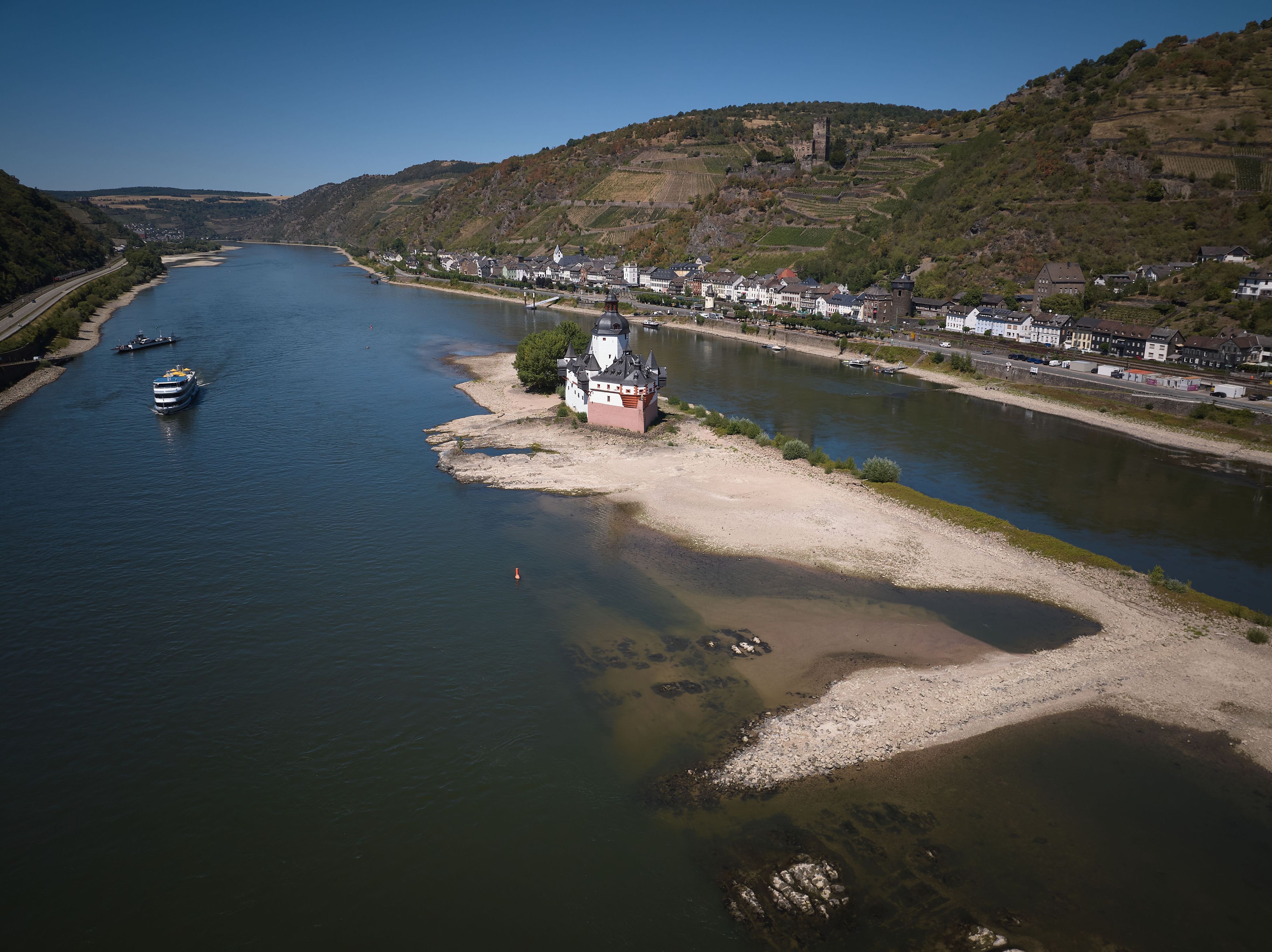 Ein Passagierschiff passiert die Zollburg Pfalzgrafenstein am Rhein bei Kaub. Aufgrund der niedrigen Wasserstände ist der Schiffsverkehr fast zum Erliegen gekommen.