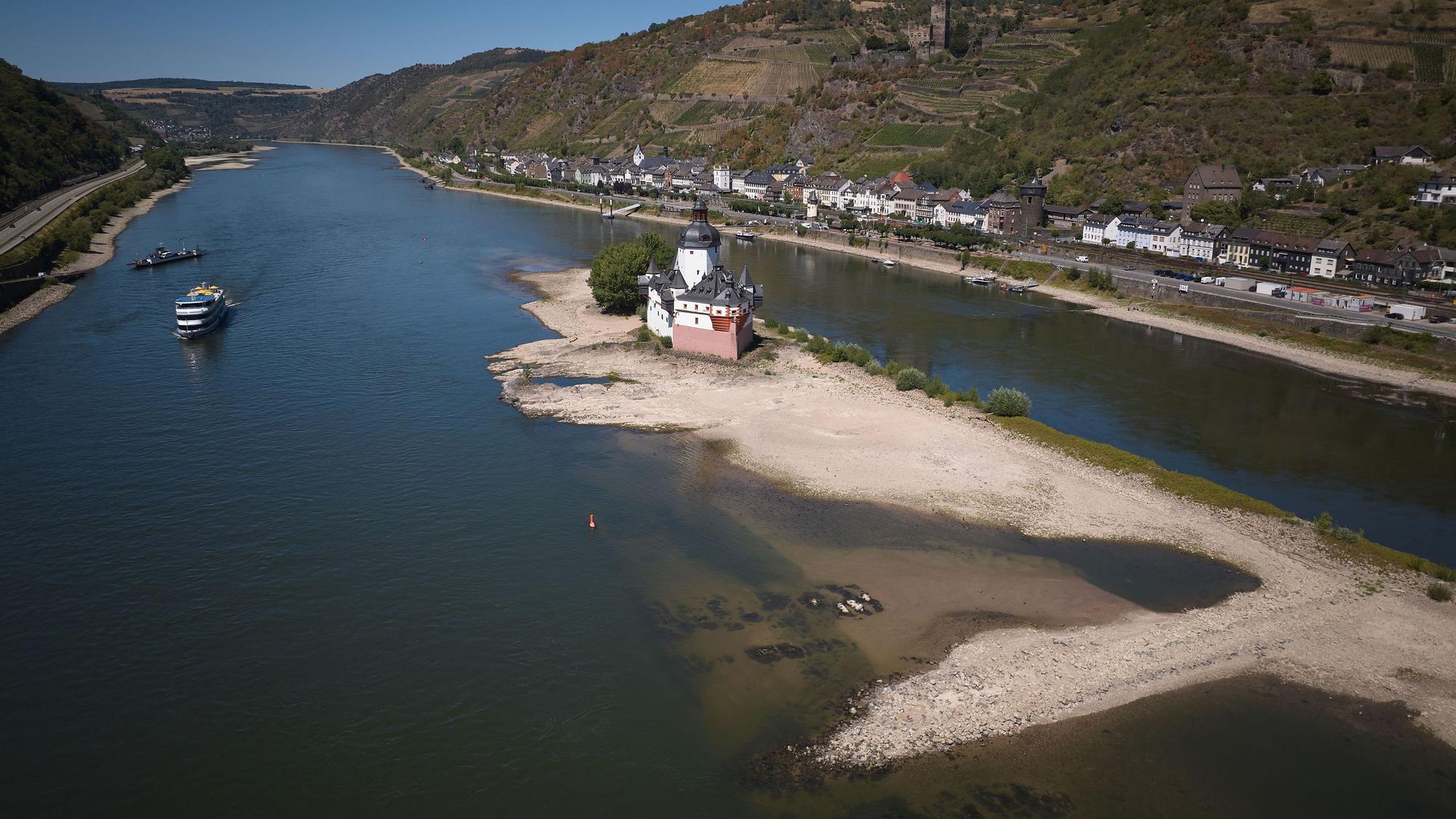 Ein Passagierschiff passiert die Zollburg Pfalzgrafenstein am Rhein bei Kaub. Aufgrund der niedrigen Wasserstände ist der Schiffsverkehr fast zum Erliegen gekommen.