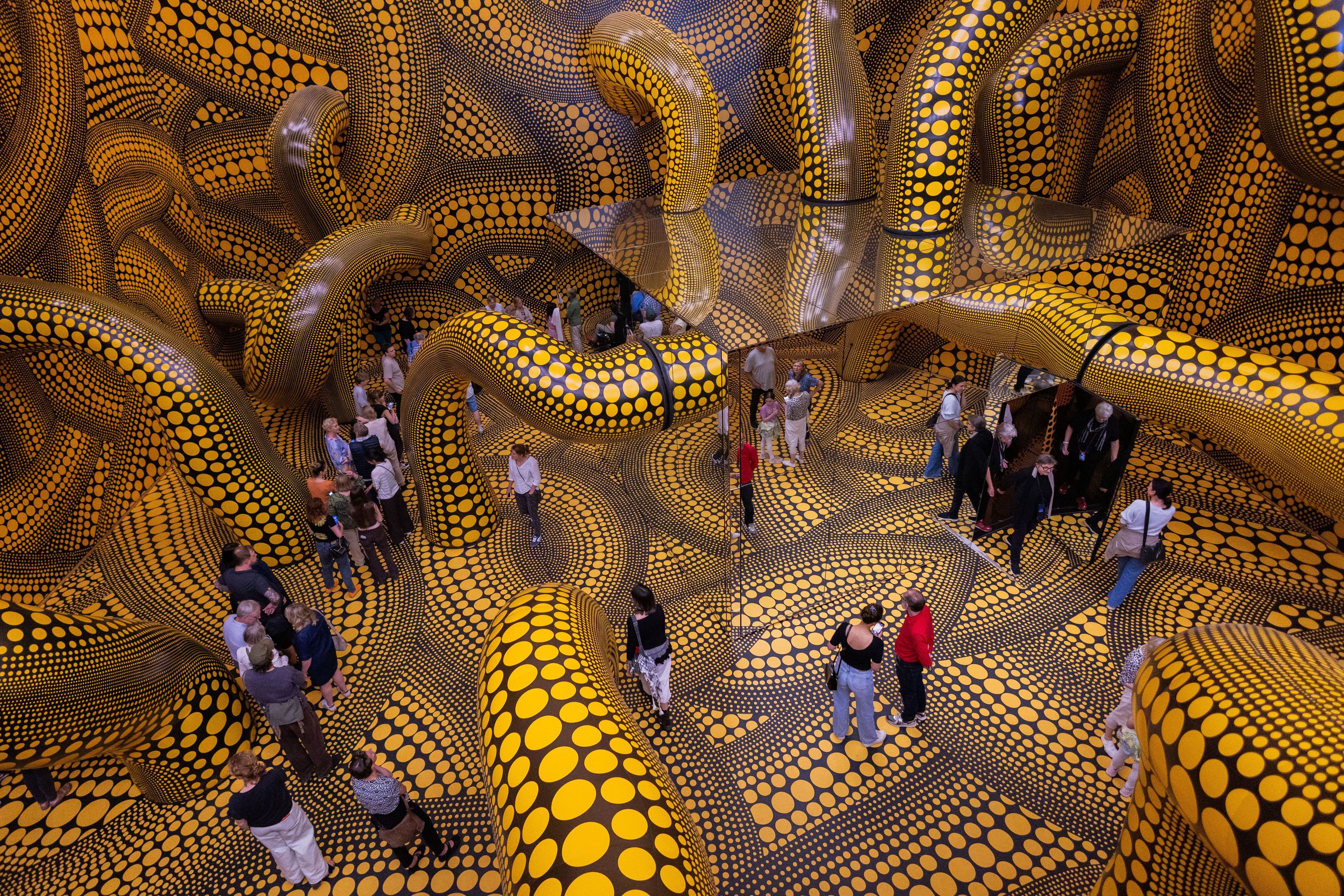 Besucher gehen durch eine Installation mit gelb gepunkteten Tentakeln im Kölner Museum Ludwig.