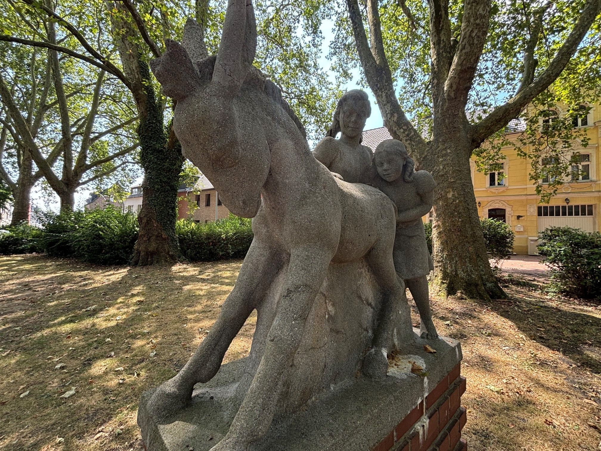 Zu sehen ist eine Skulptur zweier Mädchen mit einem Esel.