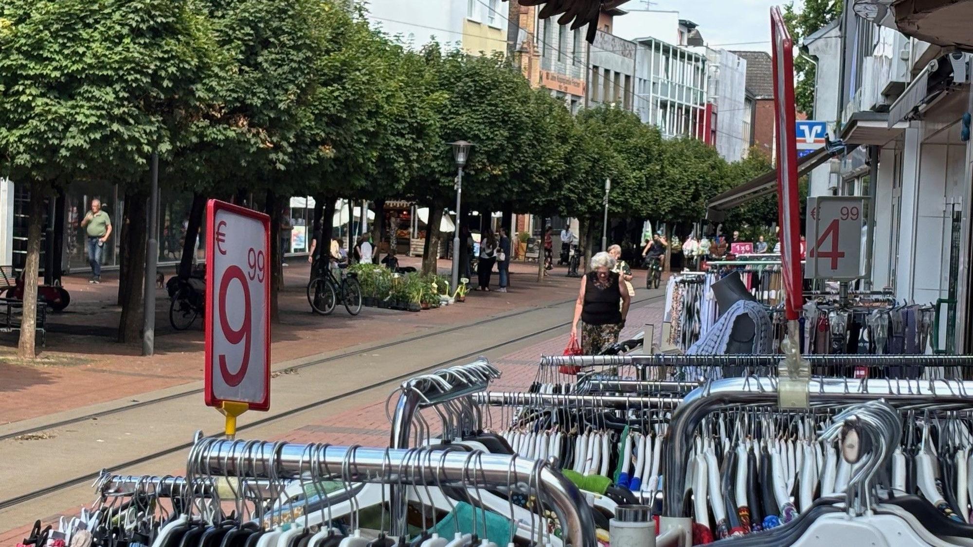Das Bild zeigt Stände eines Bekleidungsgeschäfts in der Fußgängerzone.