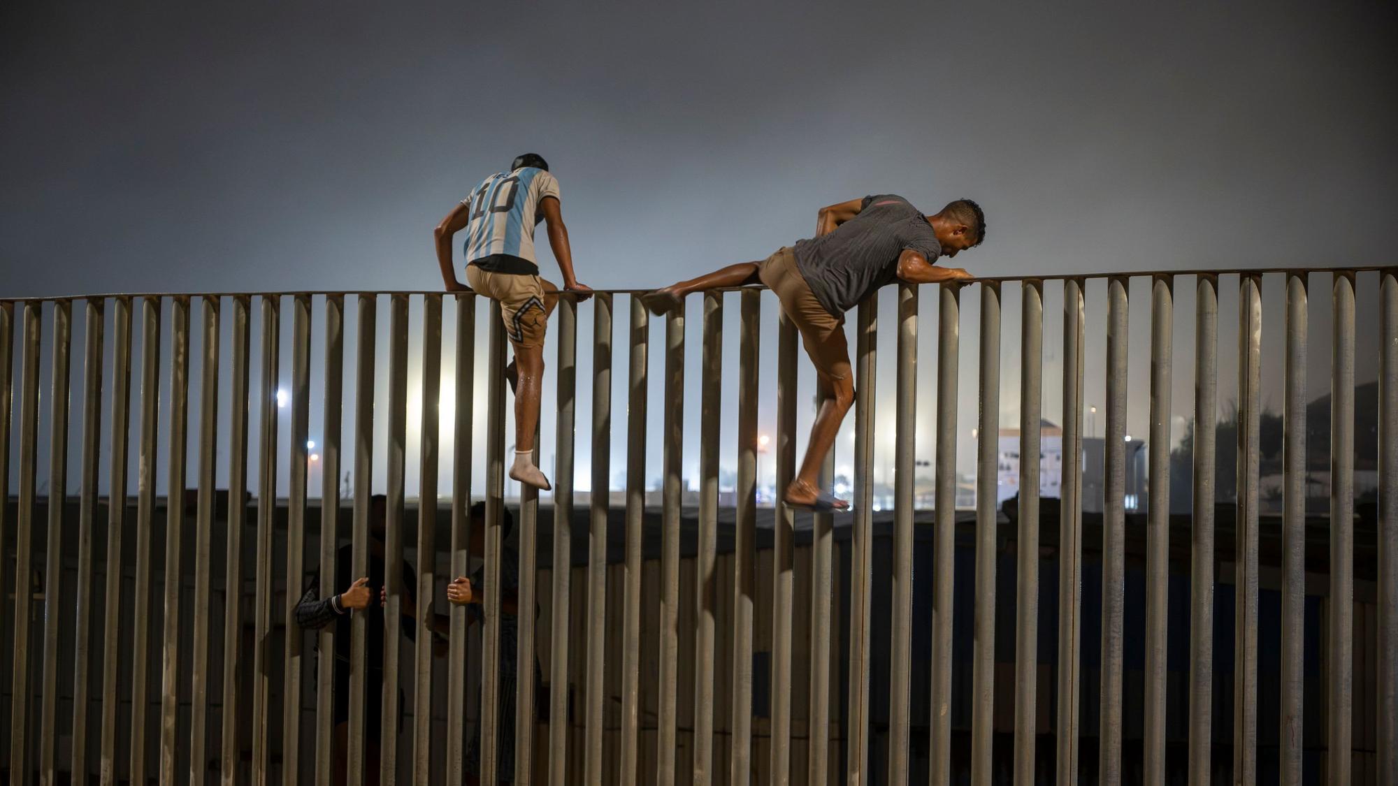 Migranten klettern über den Zaun, der die Grenze zwischen Ceuta und Marokko markiert.