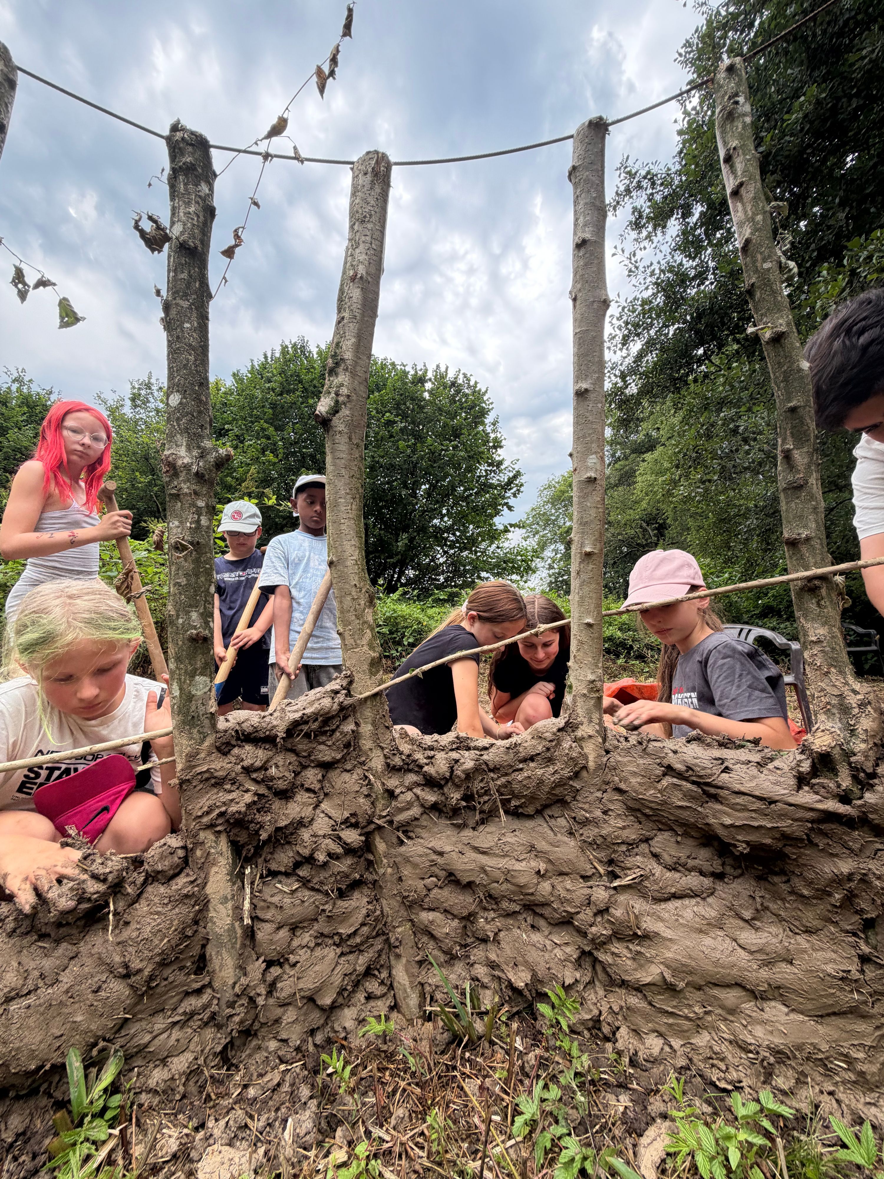 Im Ferienprogramm bauen Kinder ein Lehmhütte aus Naturmaterialien.