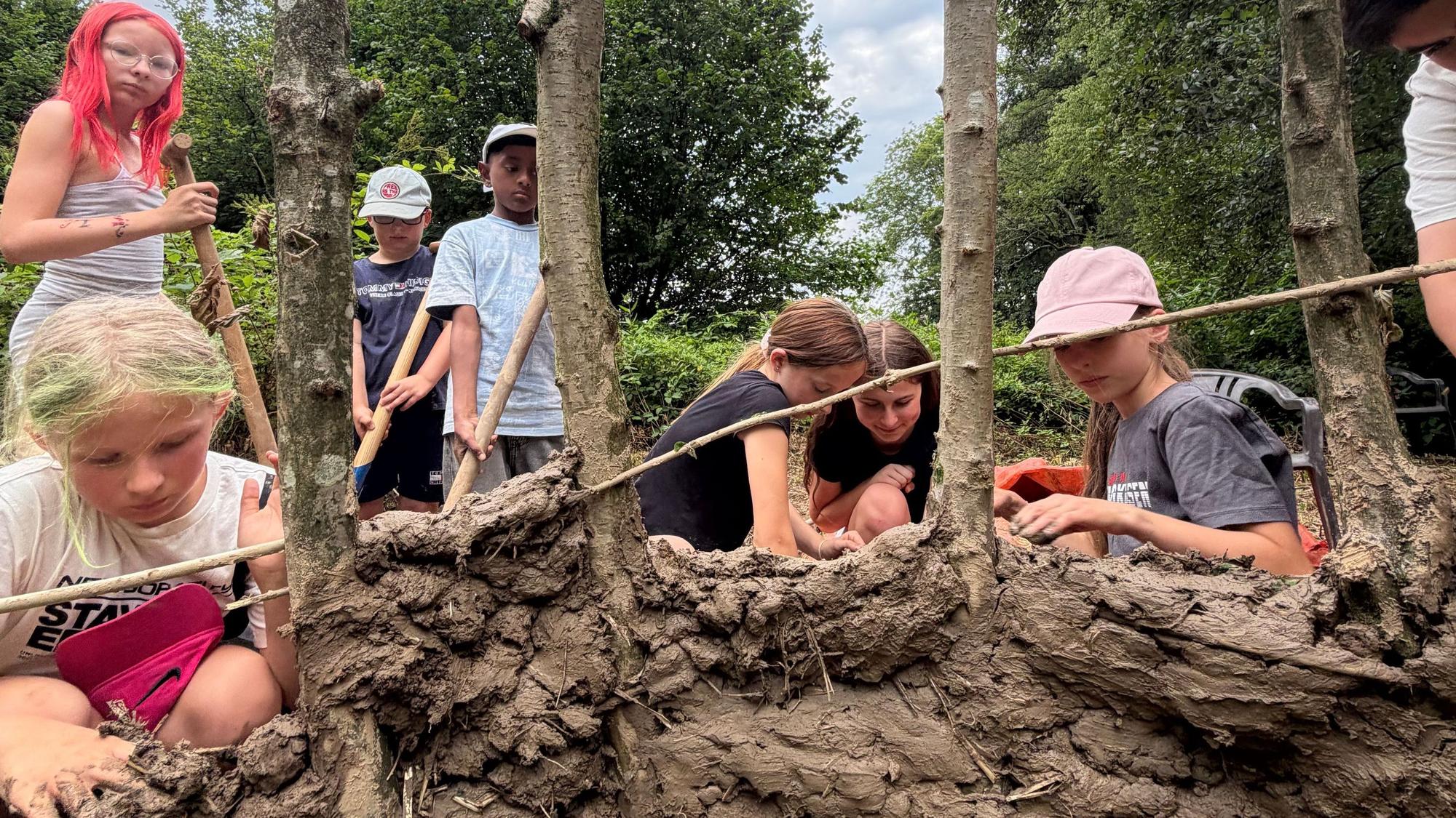 Im Ferienprogramm bauen Kinder ein Lehmhütte aus Naturmaterialien.