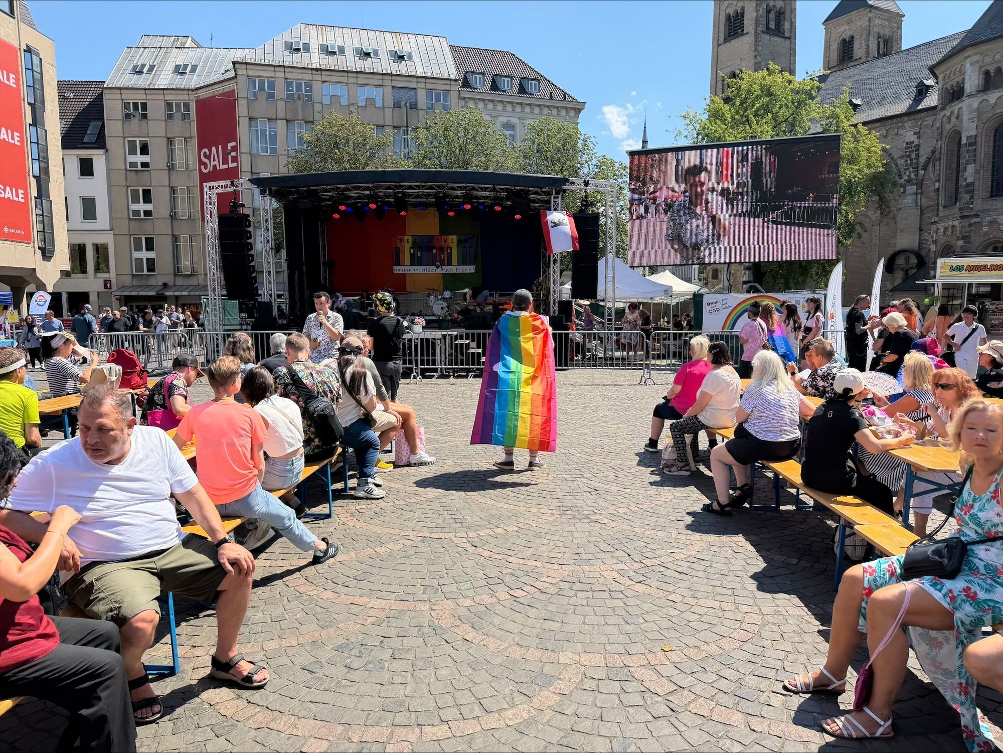 Menschen feiern auf dem Bonner Münsterplatz den Christopher Street Day 2026.