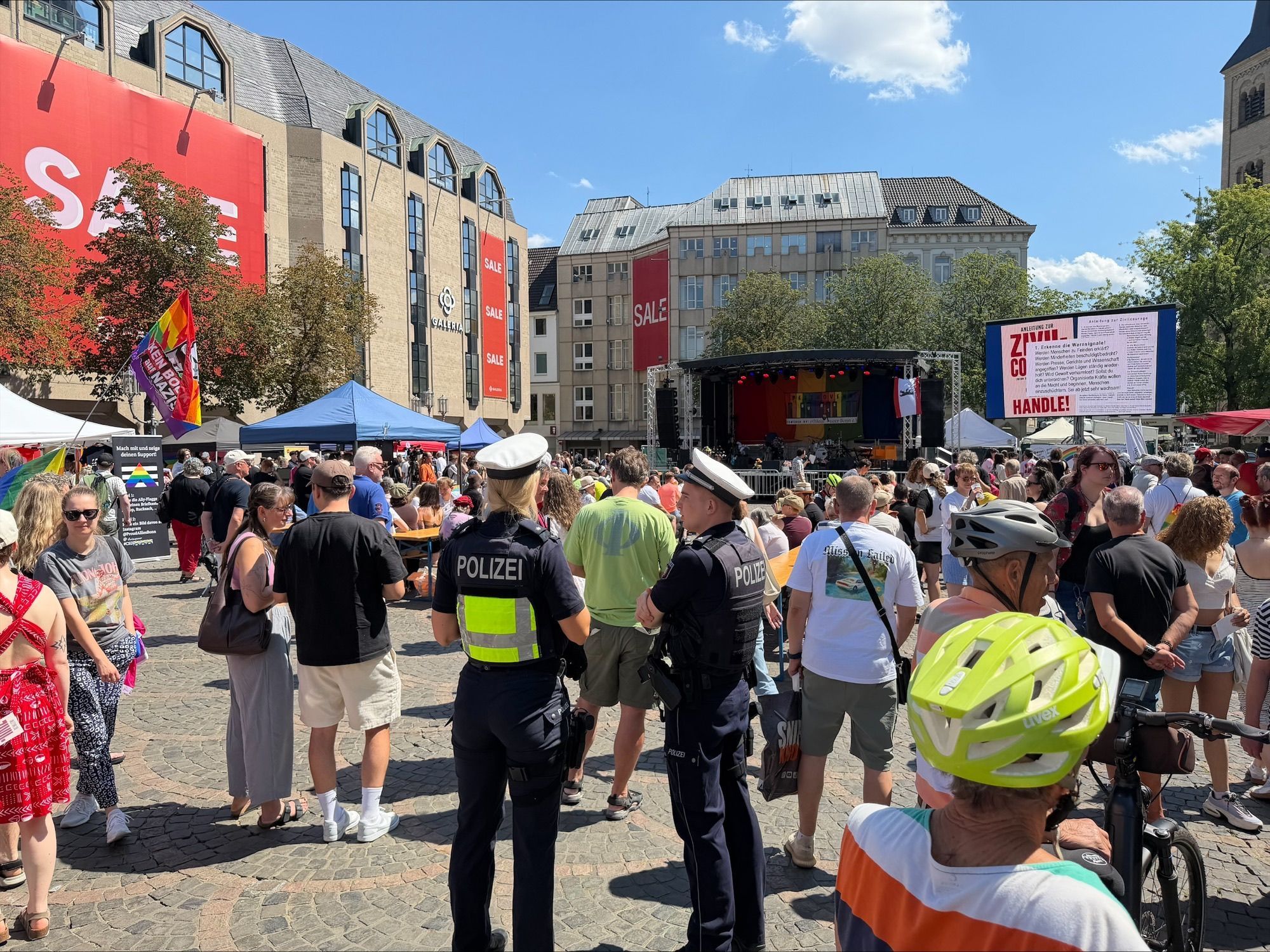 Polizeibeamte stehen während der CSD-Feier auf dem Bonner Münsterplatz.