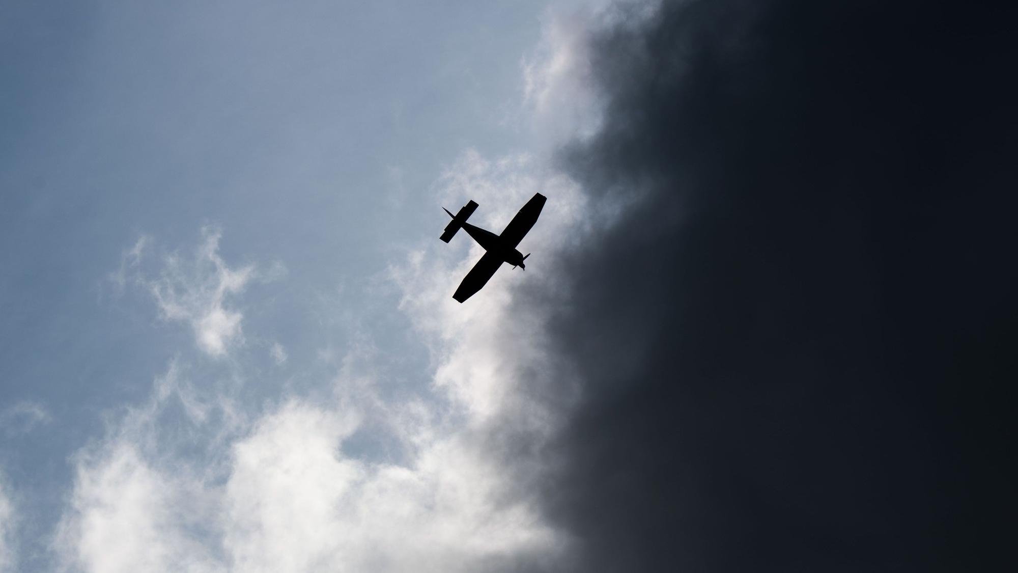 ARCHIV - 24.08.2021, Niedersachsen, Giesen: Ein Kleinflugzeug fliegt vor dunklen Wolken (Symbolfoto).