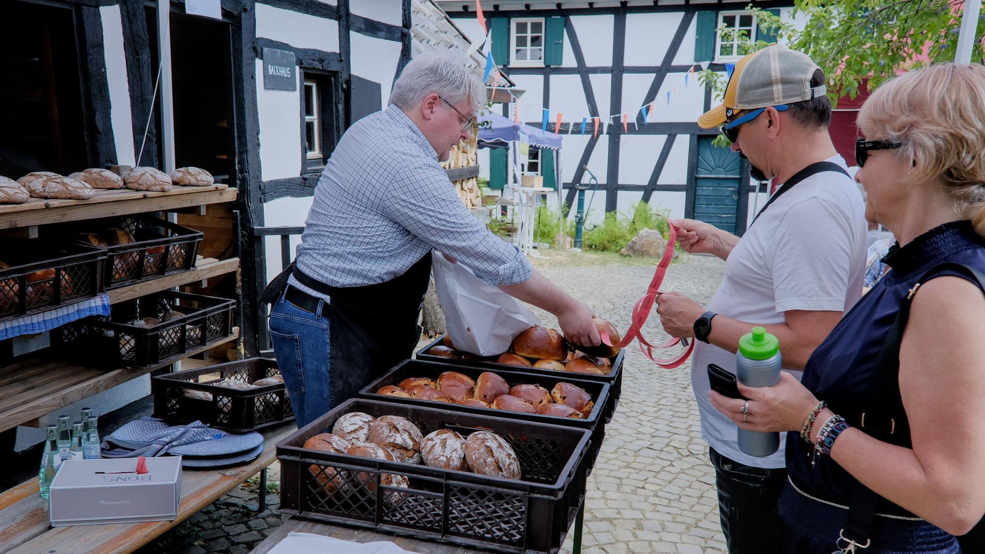 Ein Bäckermeister verkauft frisches Brot.