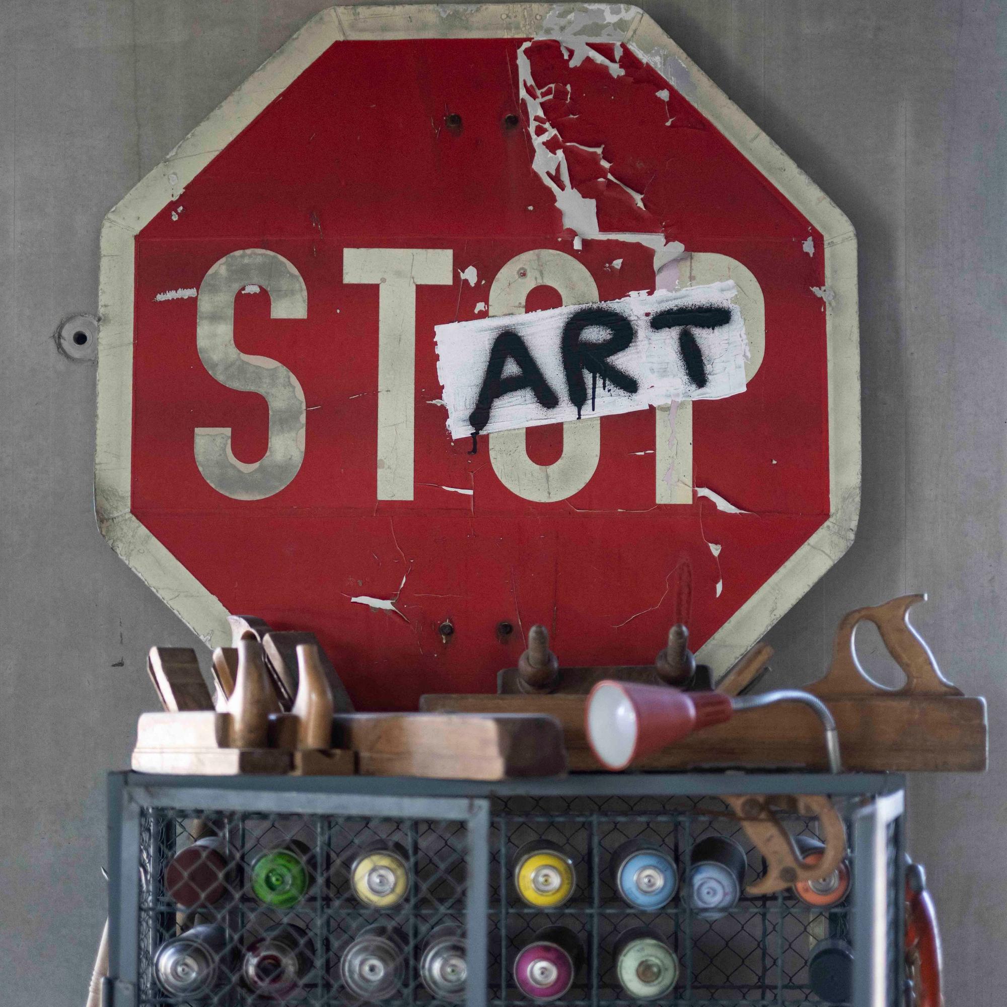 Auf einem roten Schild mit der Aufschrift Stop sind das o und das p mit einem Aufkleber überklebt, auf den art steht.