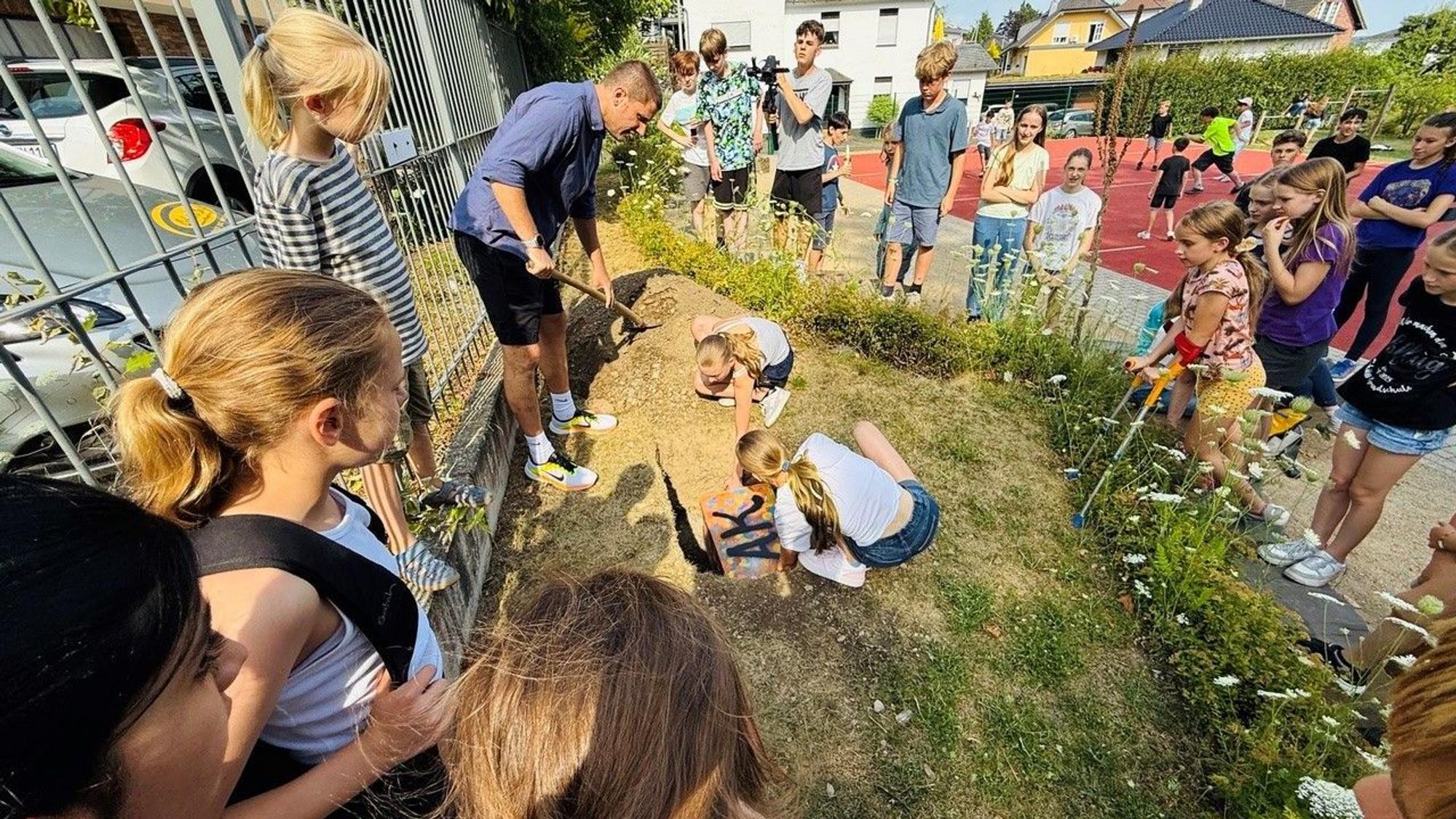 Eine Zeitkapsel mit Dokumenten vom Jubiläum haben die Schülerinnen und Schüler für die Nachwelt vergraben.