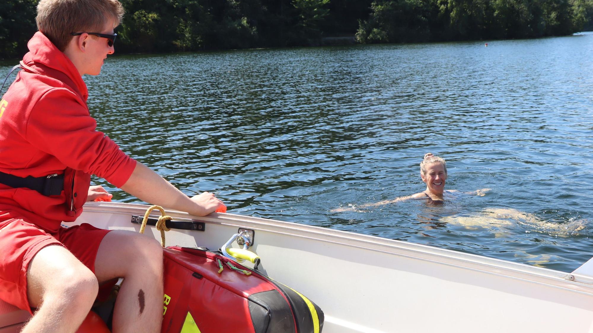 Das Bild zeigt eine Schwimmerin, die von einem DLRG-Mitarbeiter angesprochen wird.