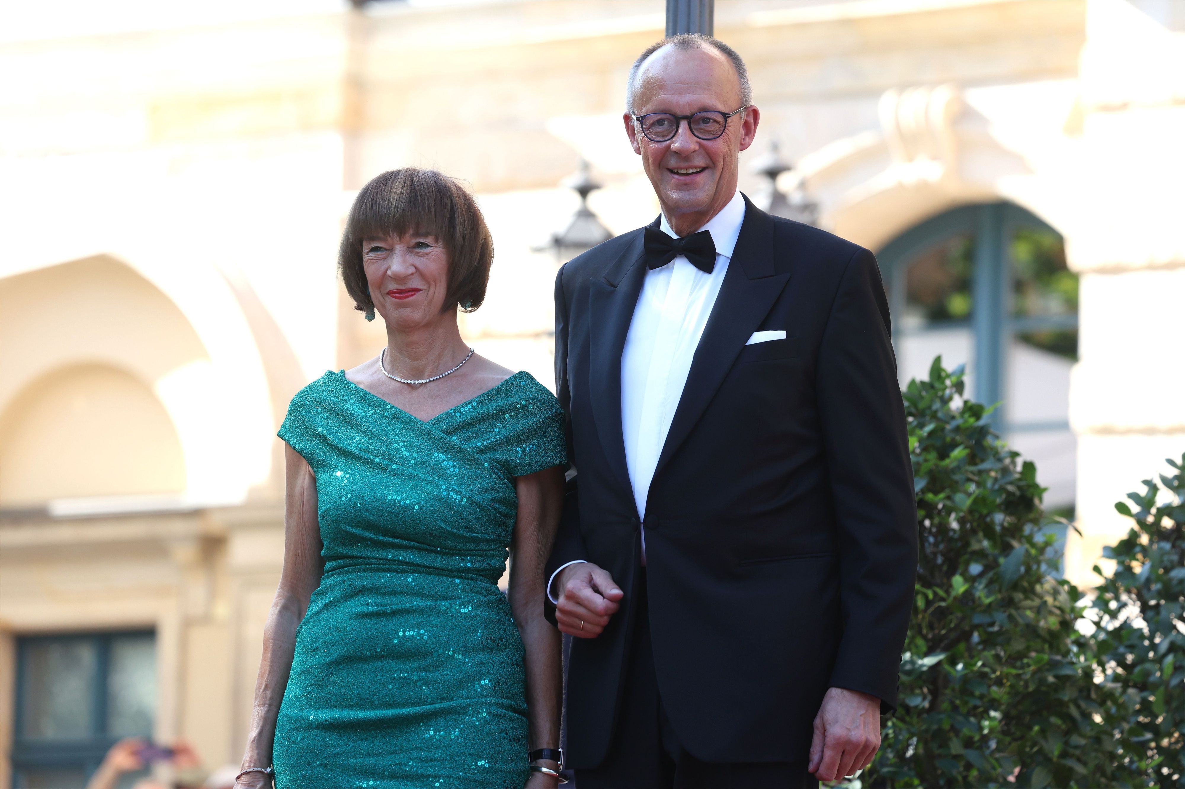 Schon ein kleiner Vorgeschmack auf den Urlaub? Bundeskanzler Friedrich Merz (r., CDU) und seine Frau Charlotte Merz kommen am 25. Juli zur Eröffnung der Richard-Wagner-Festspiele zum Festspielhaus Bayreuth.