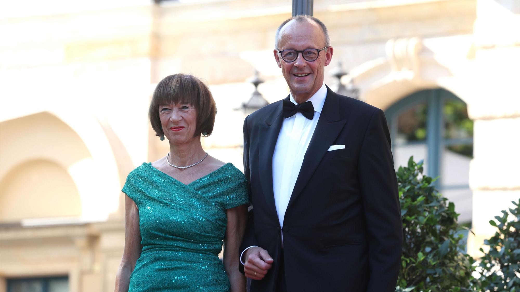 Schon ein kleiner Vorgeschmack auf den Urlaub? Bundeskanzler Friedrich Merz (r., CDU) und seine Frau Charlotte Merz kommen am 25. Juli zur Eröffnung der Richard-Wagner-Festspiele zum Festspielhaus Bayreuth.