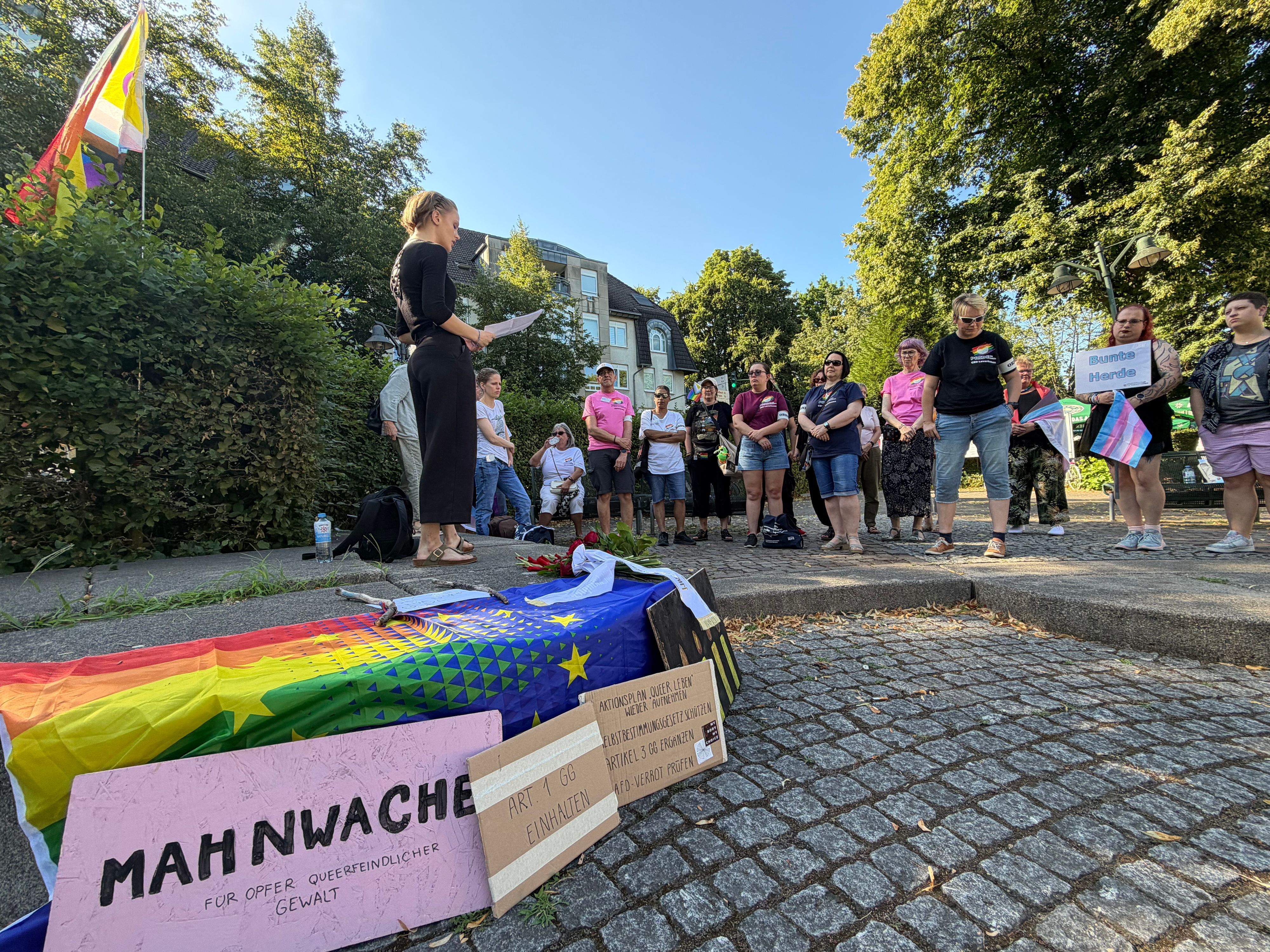 Ronja Eppert (l.) spricht kurz zu den versammelten Menschen, dann beginnt eine Schweigestunde als Mahnwache am Schlebuscher Lindenplatz.