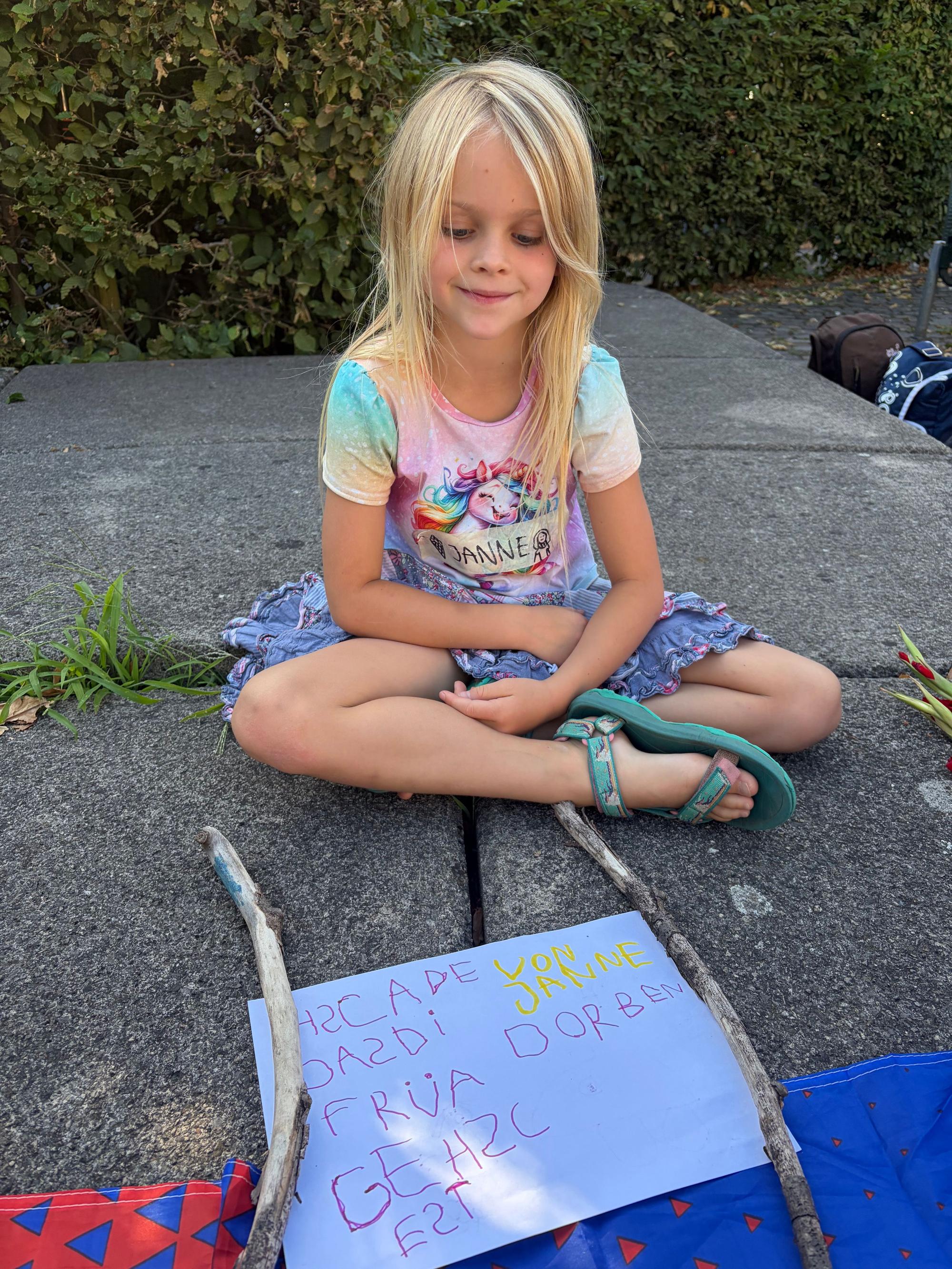 Die sechsjährige Janne mit ihrem selbst geschriebenen Plakat: „Schade, dass die Frau gestorben ist.“