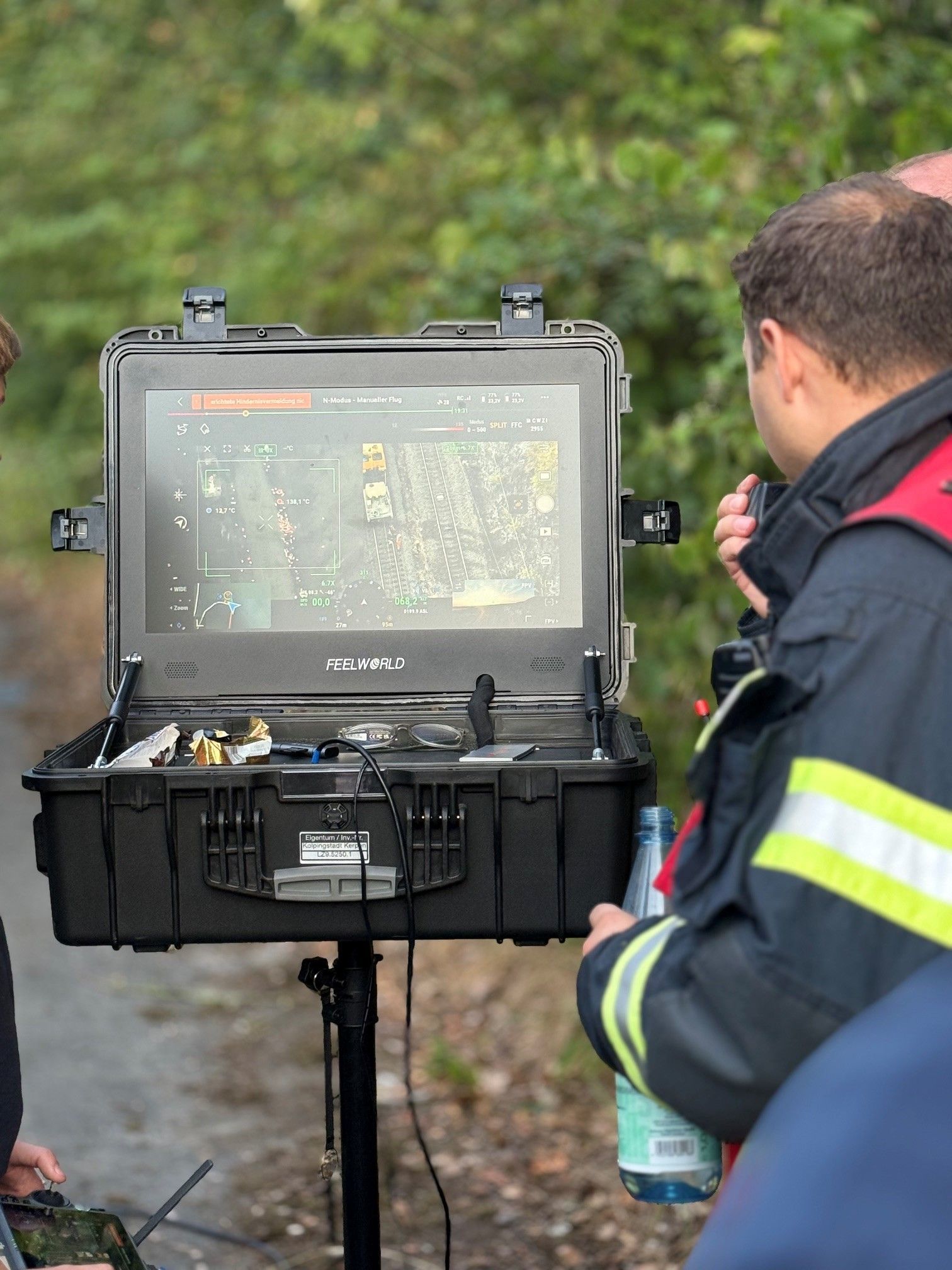 Das Bild zeigt einen Feuerwehrmann vor einem Bildschirm.