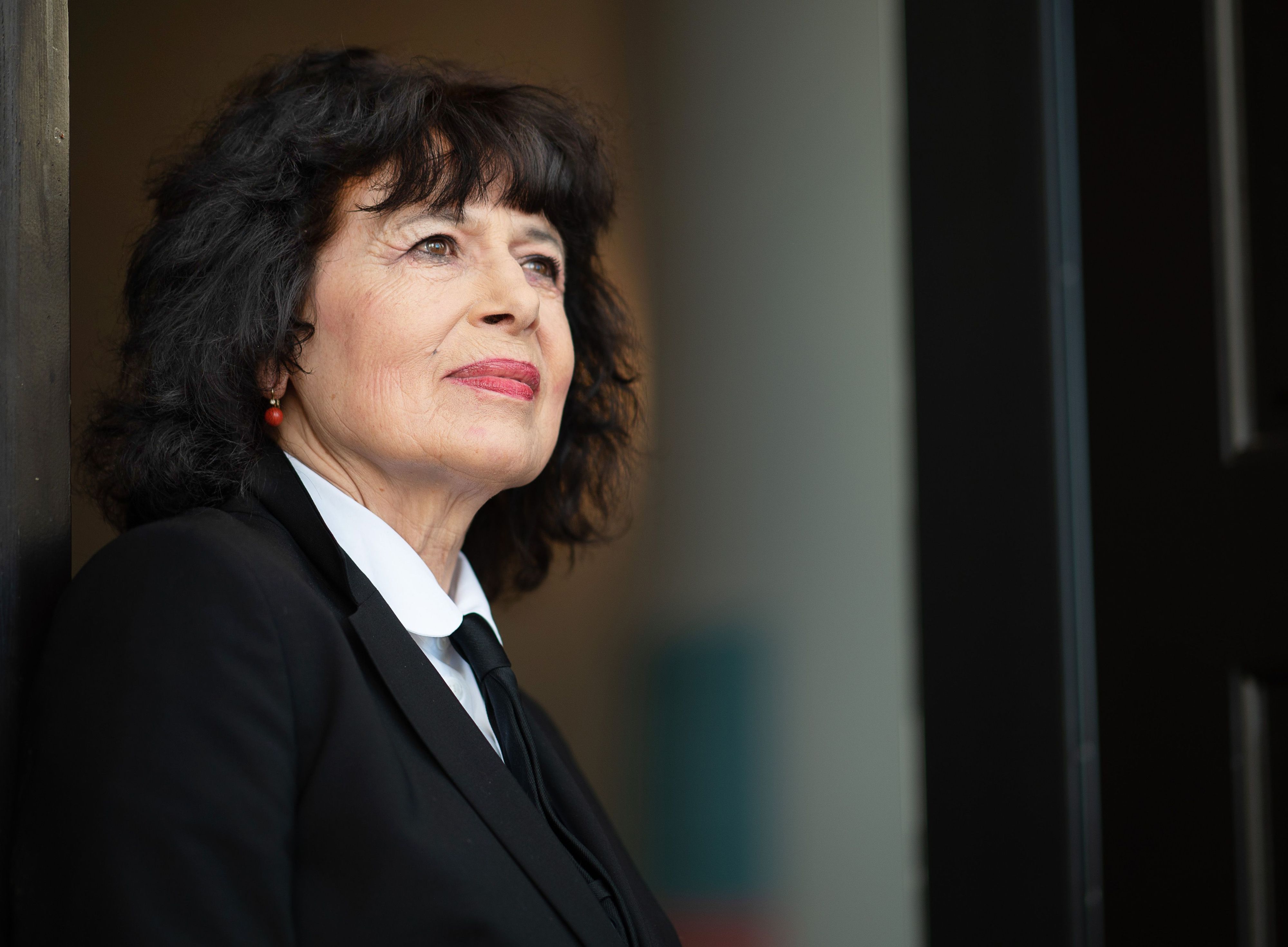 Eine Frau blickt ernst an der Kamera vorbei.